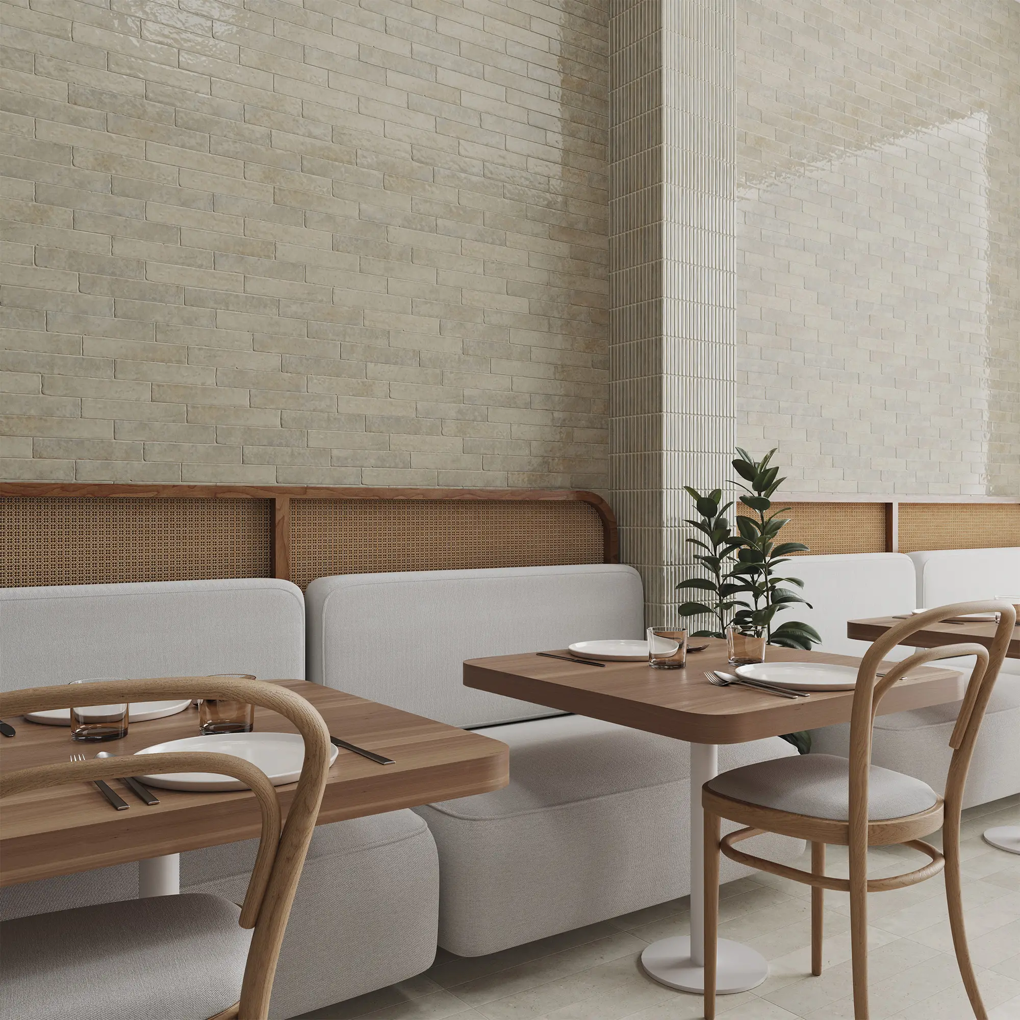 Mesa de restaurante con platos, cubiertos y plantas decorativas, en un ambiente minimalista con paredes de ladrillo y mobiliario de madera clara.