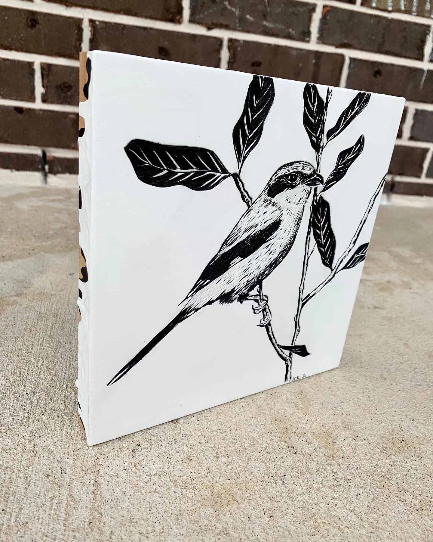 Black and white illustration of a bird perched on a branch with leaves, on a white canvas.