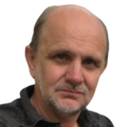 A middle-aged man with a bald head and beard, wearing a dark jacket, looking at the camera.
