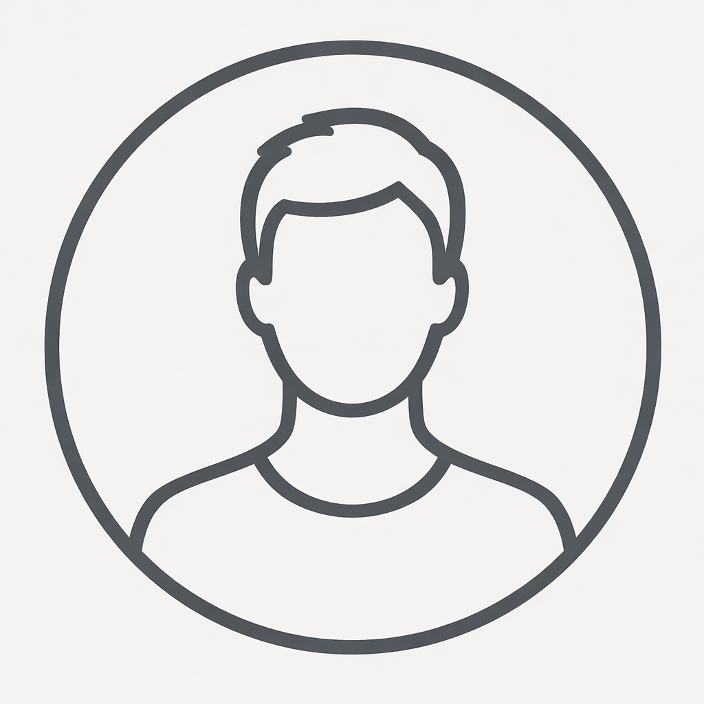 A young man with light brown hair wearing a dark suit, white shirt, and striped tie standing outdoors in front of a blurred background of a building with white columns.