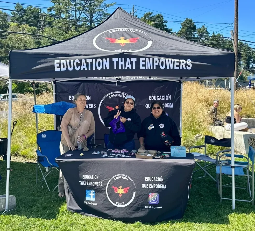 Image of Conexión Fénix staff at a tabling event to empower families and provide information about local resources