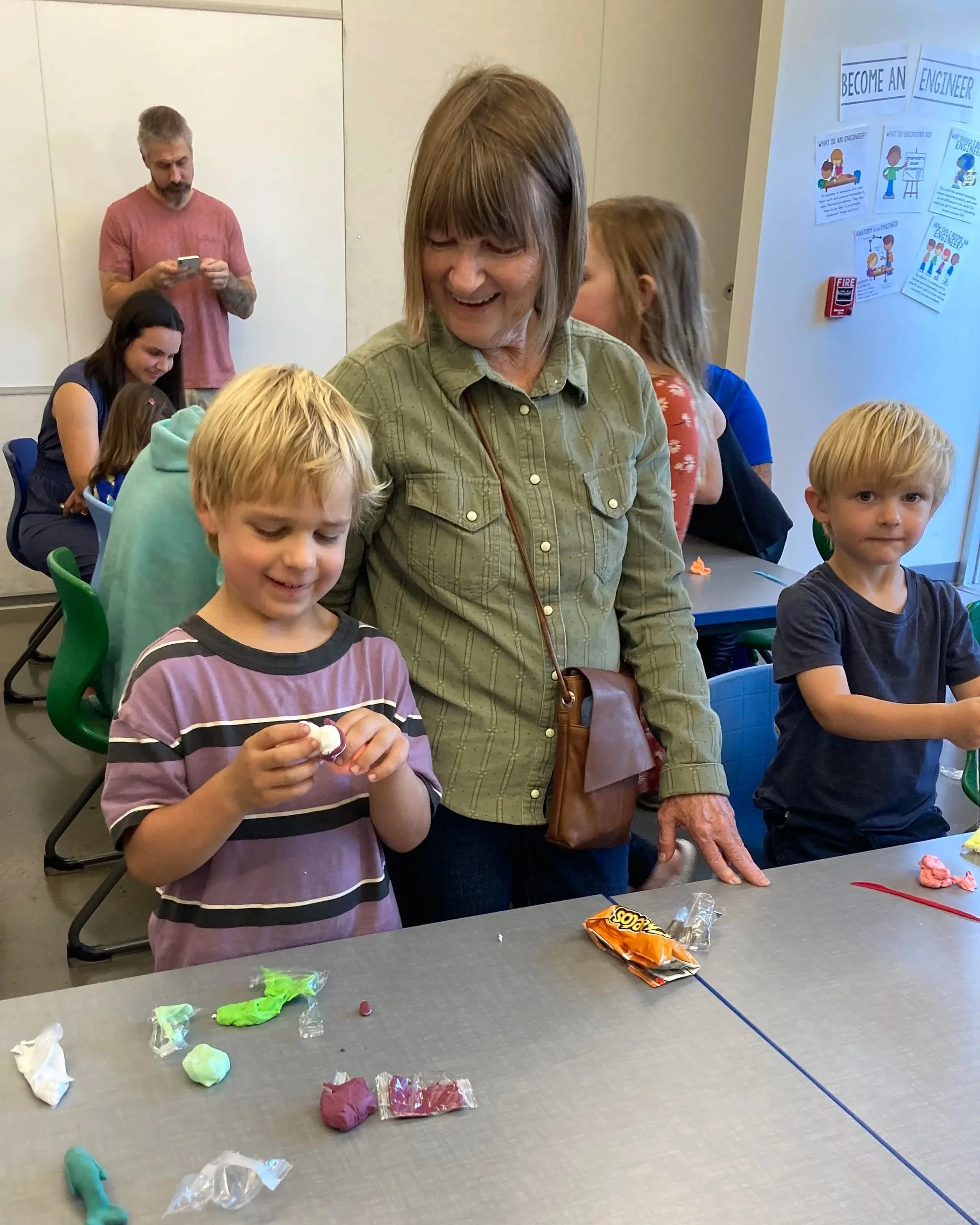 Two children and their grandmother work on clay sculptures during a parenting workshop in Corvallis School District.