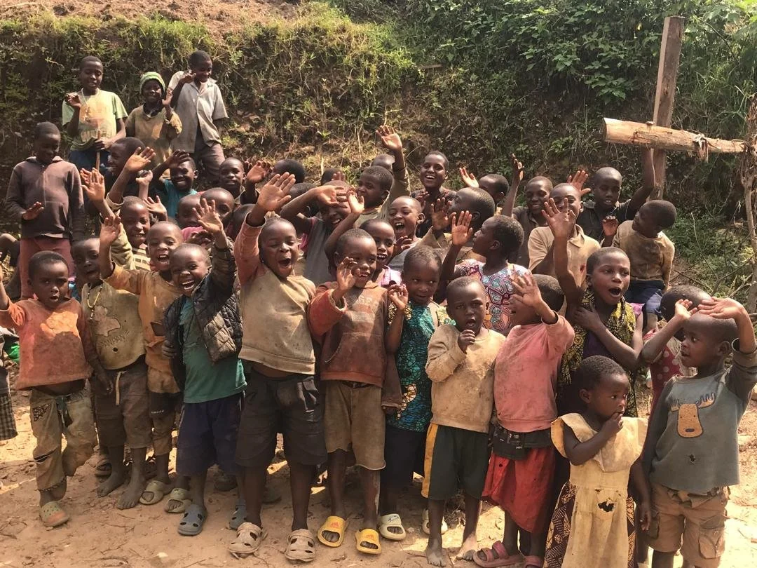 Children in Uganda waving to the camera.