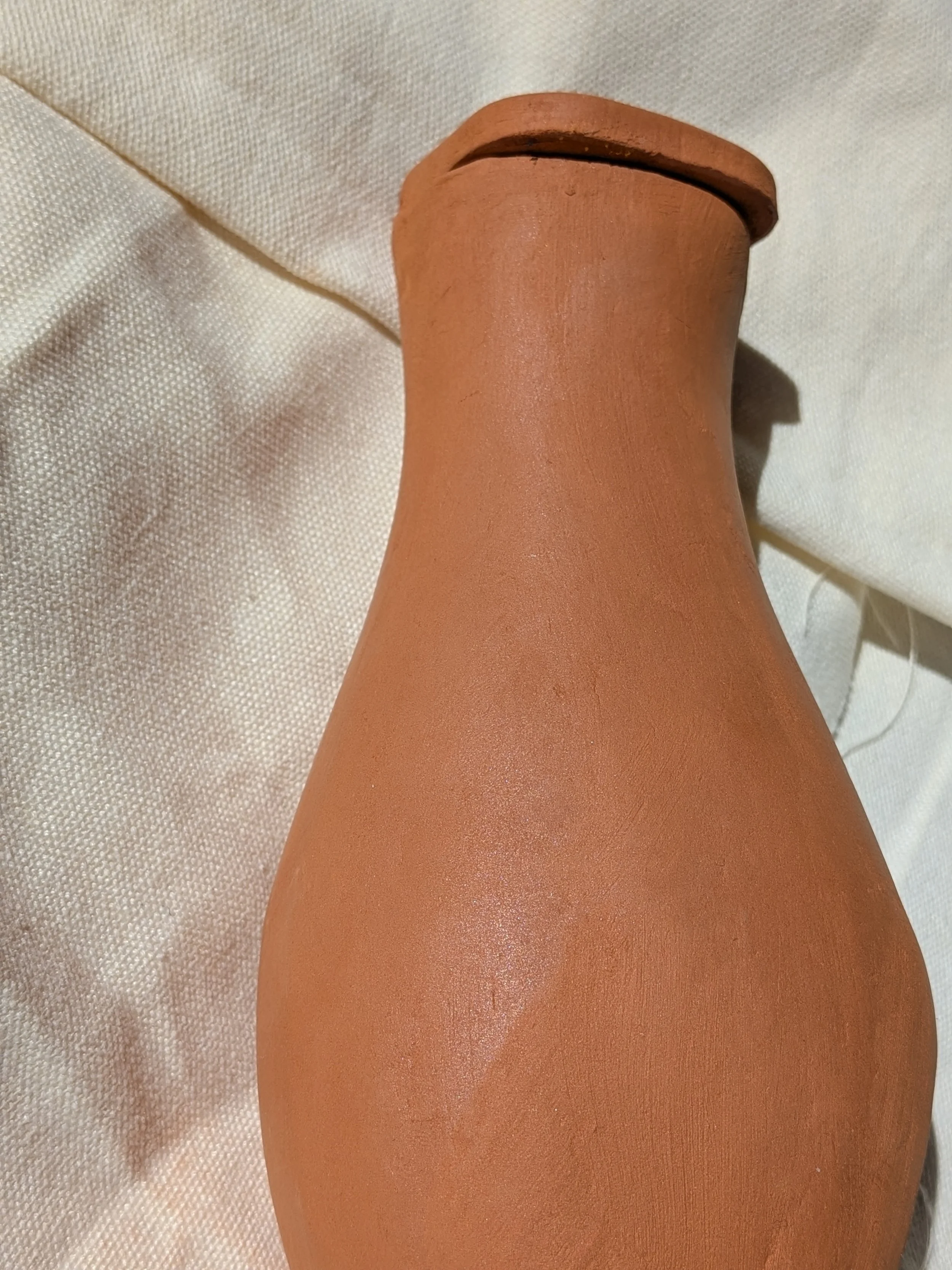 Hand-built terracotta sweat pot olla for garden irrigation by Gnomestead Pottery.