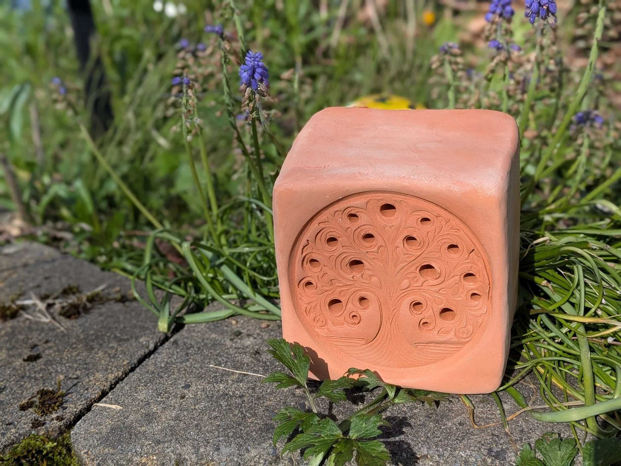 Hand-built terracotta bee and bug hotel home with intricate tree design for garden pollinators by Gnomestead Pottery.