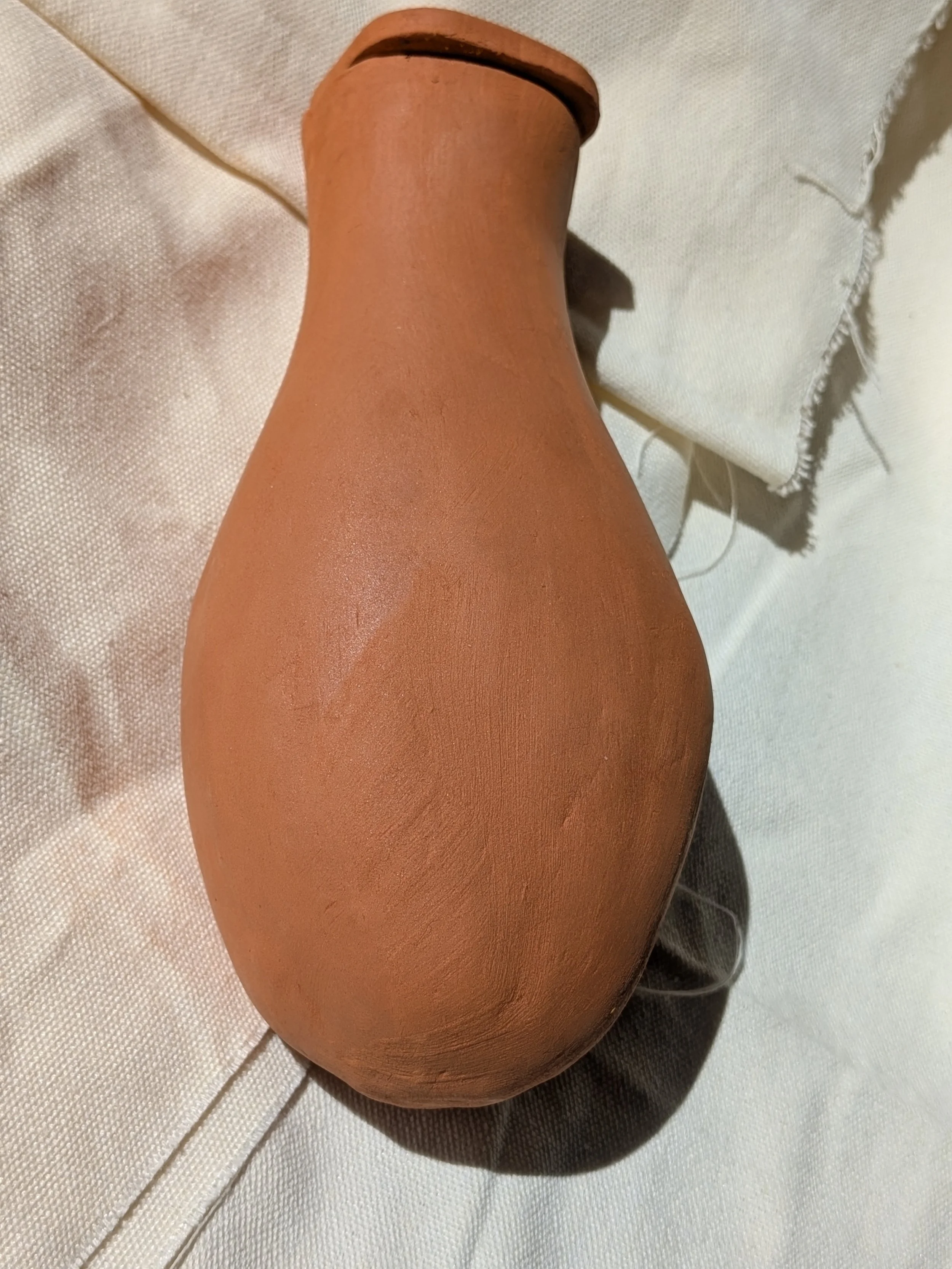 Hand-built terracotta sweat pot olla for garden irrigation by Gnomestead Pottery.