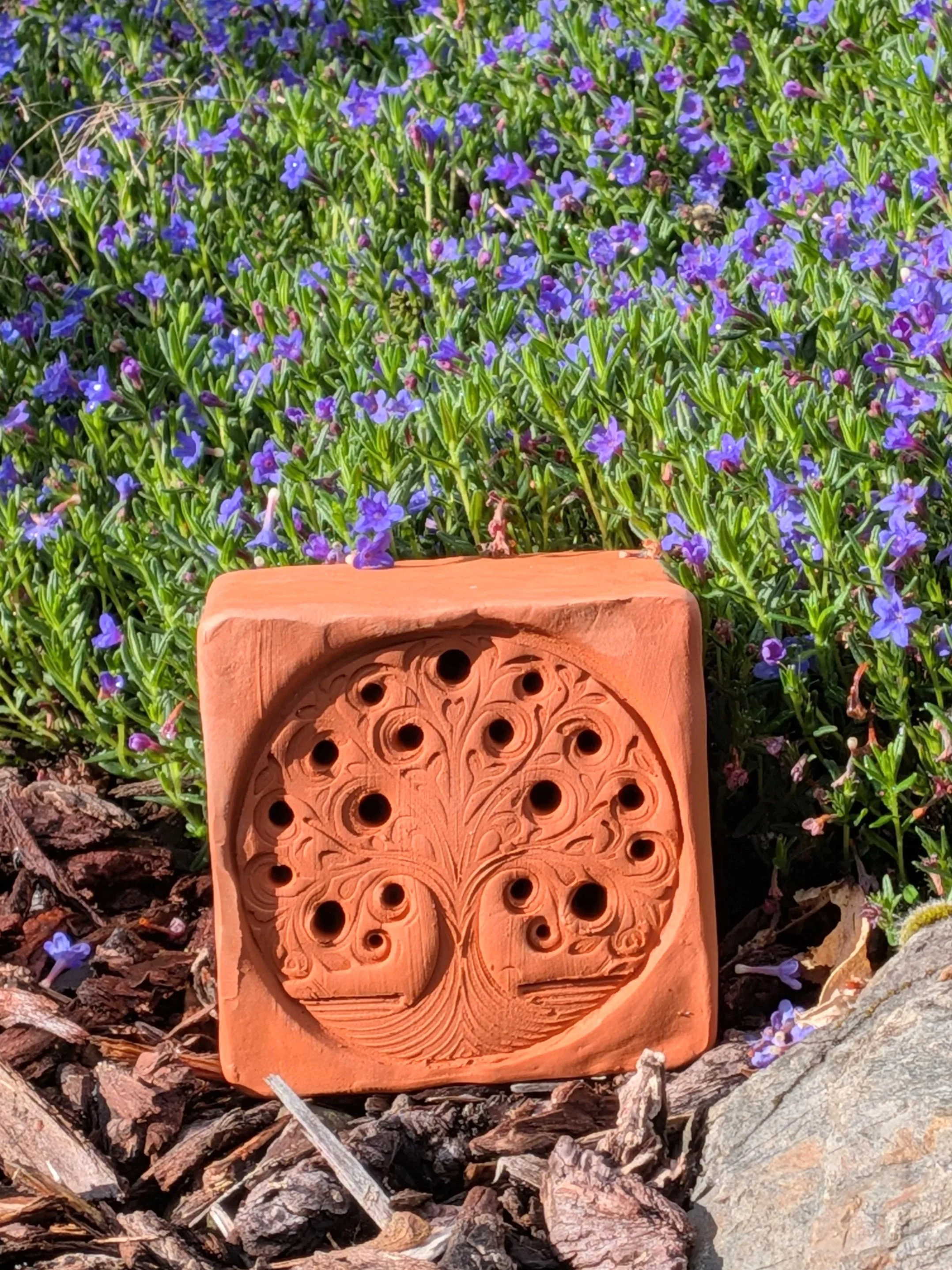 Hand-built terracotta bee and bug hotel home with intricate tree design for garden pollinators by Gnomestead Pottery.