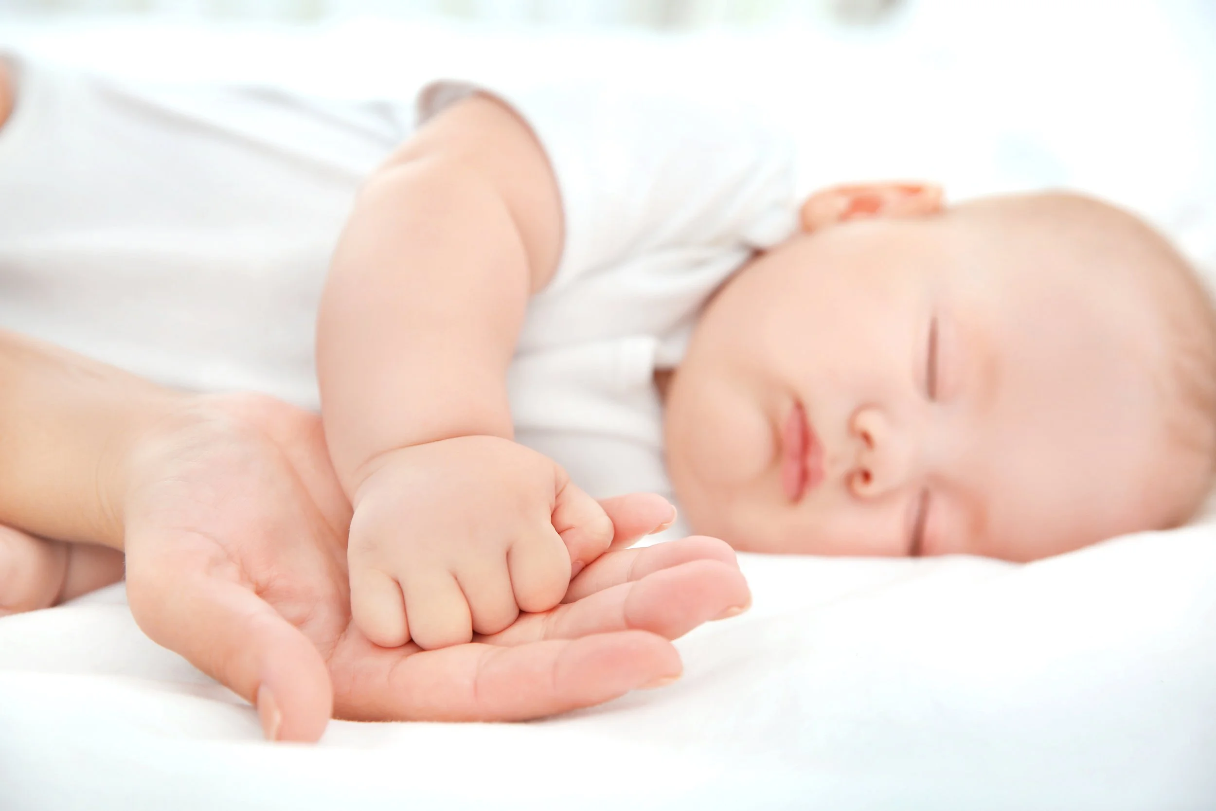 Baby sleeping peacefully, showing calm and relaxation supported by gentle baby massage