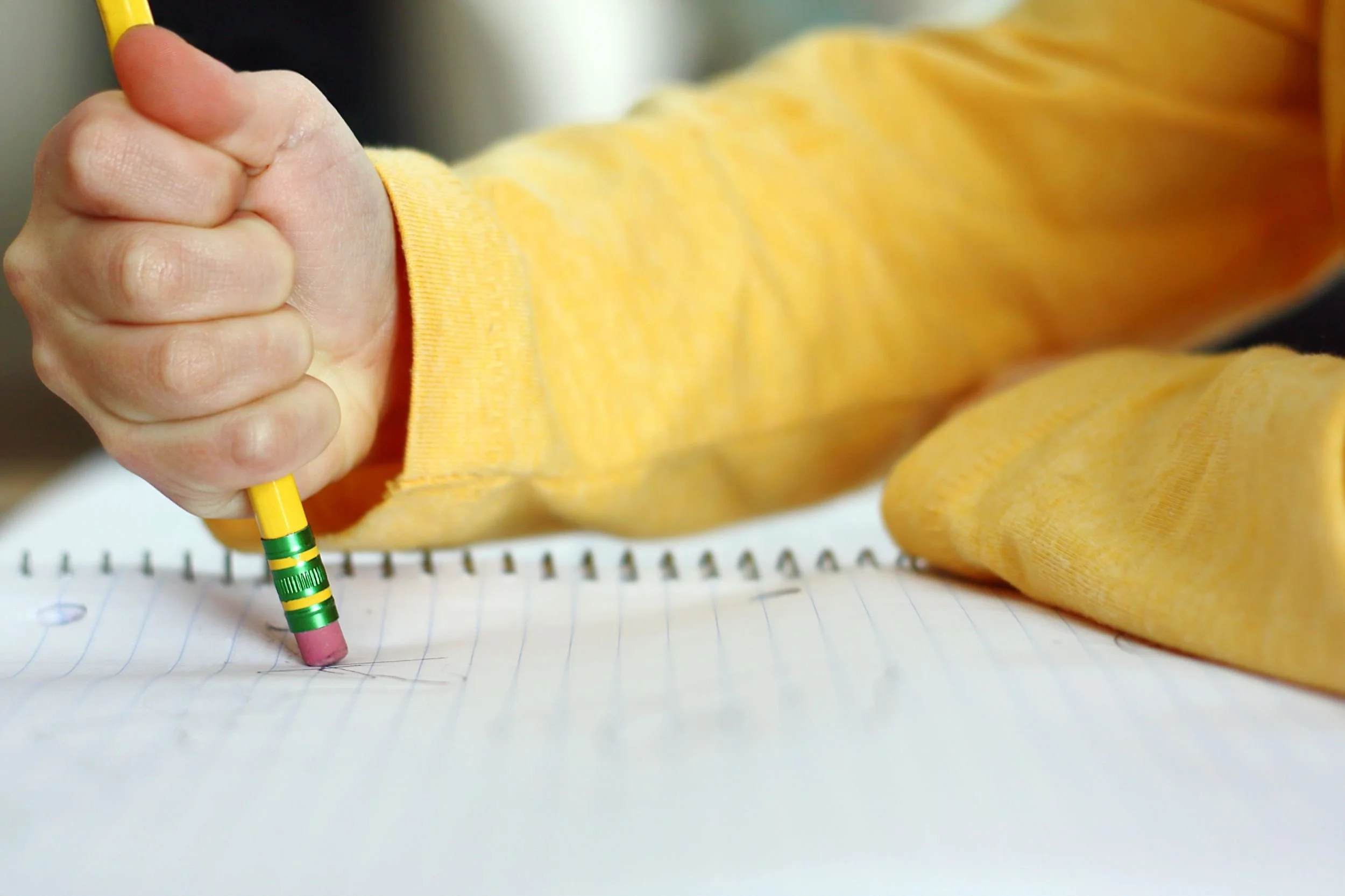 Child using an early pencil grip, showing developing fine motor skills that may relate to retained primitive reflex patterns