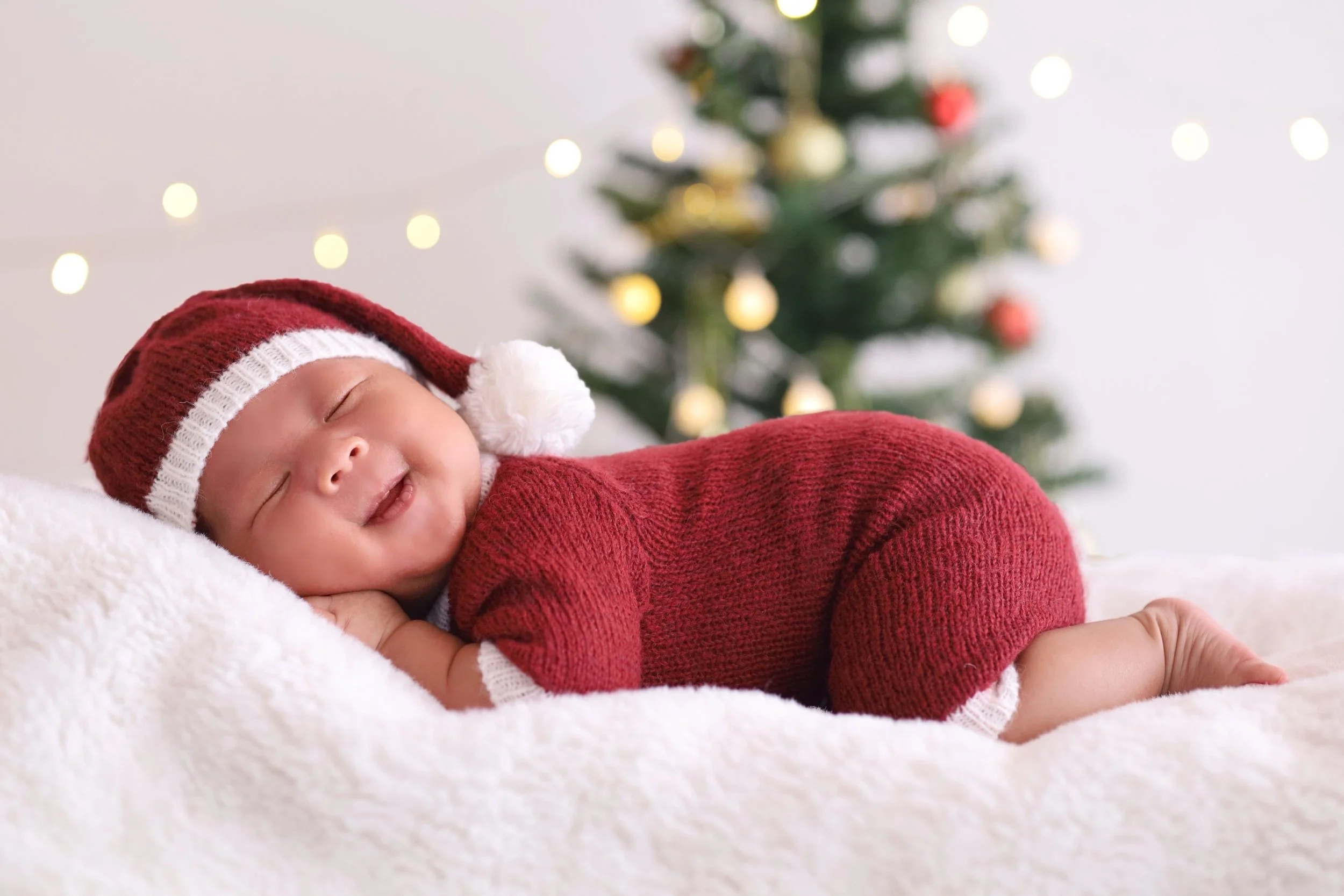 Baby sleeping in a Santa onesie, showing a calm and cozy moment during the Christmas season