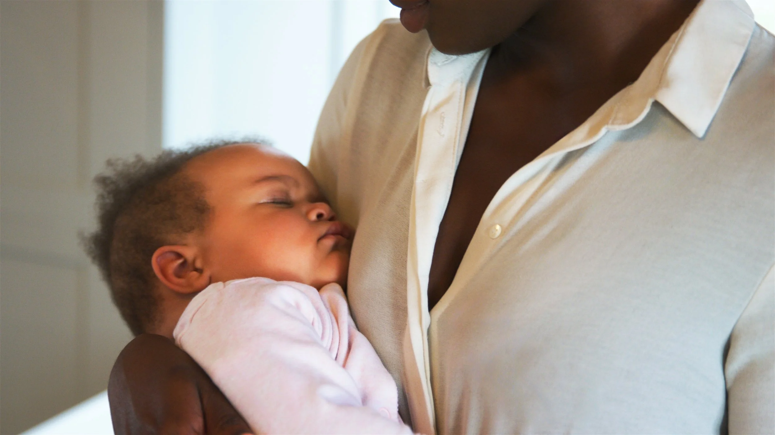Father holding a sleeping baby in a calm bedtime setting, showing how baby massage supports relaxation and sleep at Best Beginnings