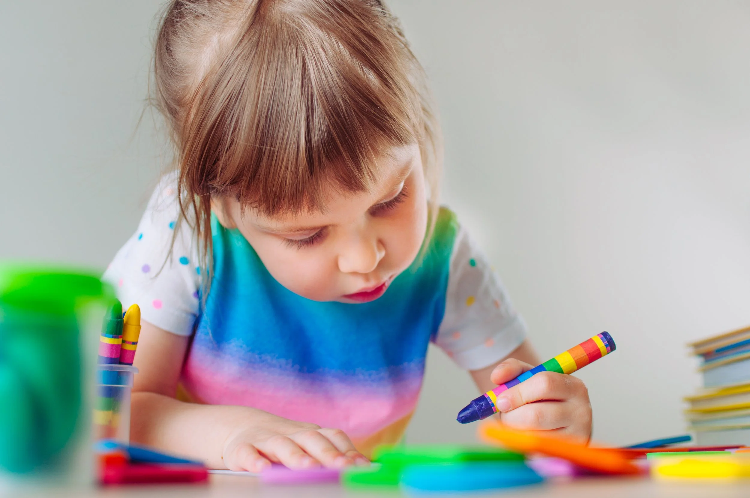 Young child coloring, showing fine motor development, hand coordination, and early learning skills