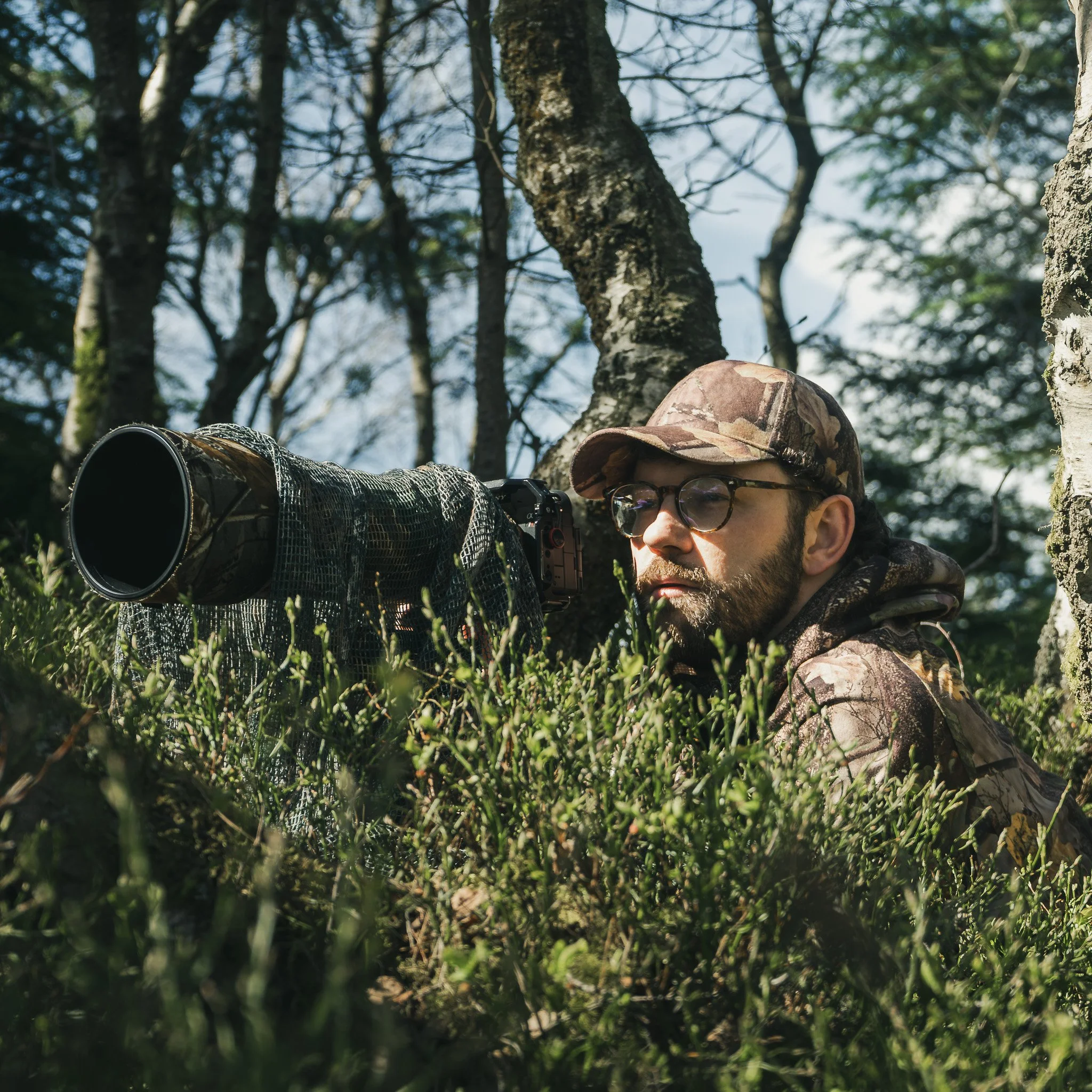 Wildlife photographer waiting to take a video or photo of wildlife, camoflauge gear and clothing being used to hide their location