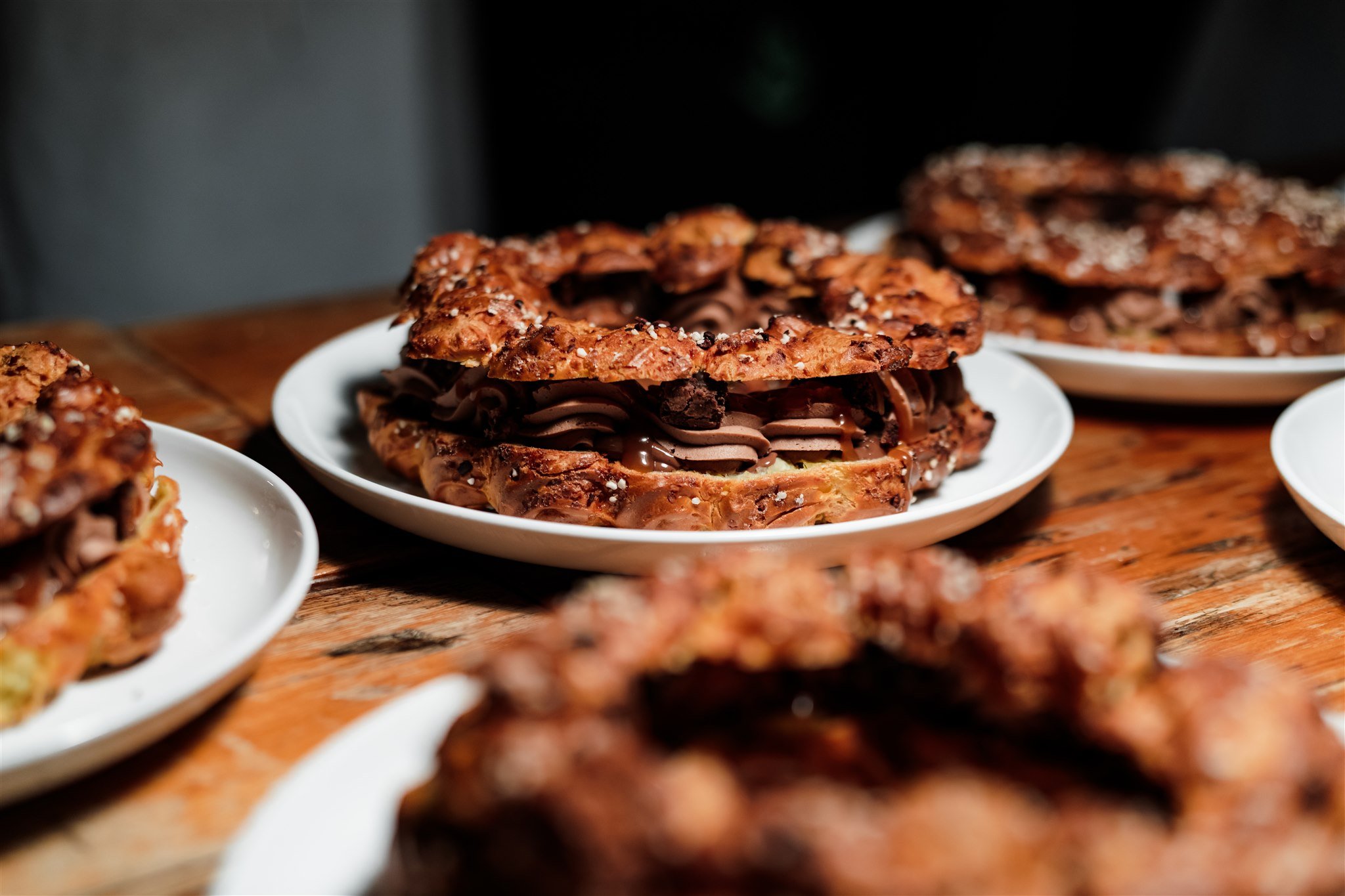 Chocolate and cookie pastry with a flaky crust and sprinkled salt, on a white plate.