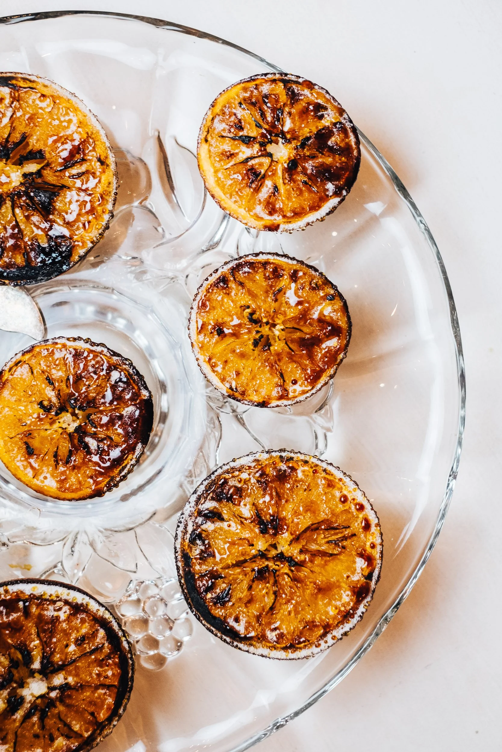 Charred lemon halves on a glass serving platter.