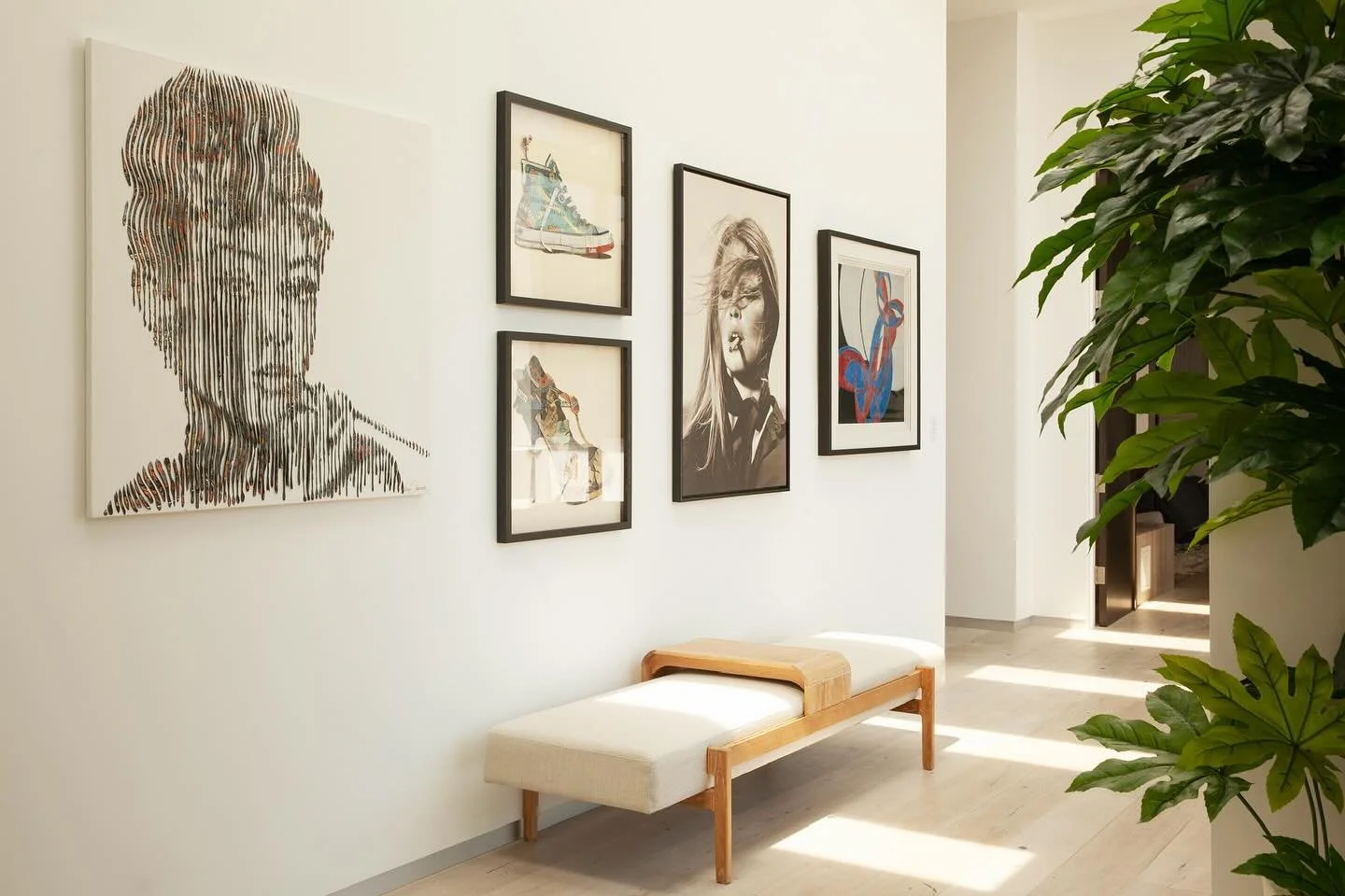 A tantalizing artwork of Audrey Hepburn by @virginie_schroeder hangs on the hallway with a photograph of Brigette Bardot and other art pieces, creating gallery wall moment. The skylights also cast beautiful shadows. #gallerywall #hallway #artcurator