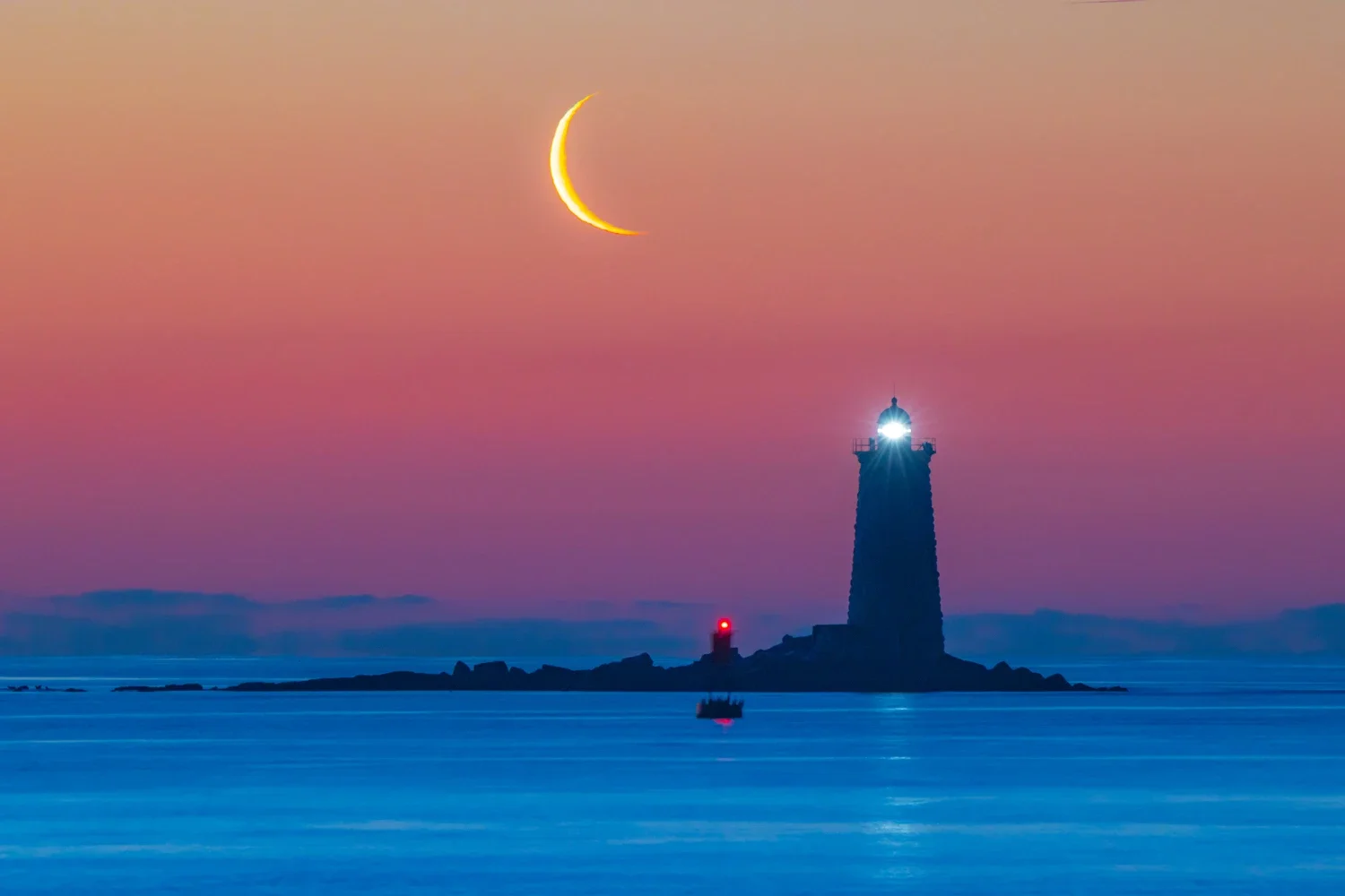 Crescent moon over Whaleback with lights on