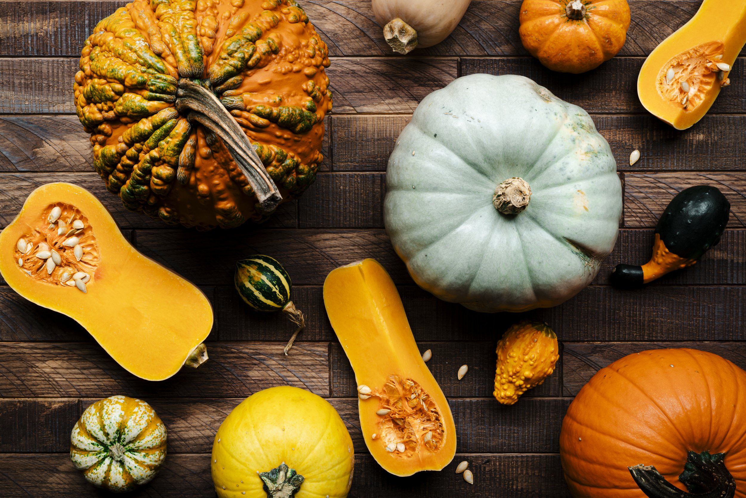 a selection of pumpkins and squash on a wood table.jpg