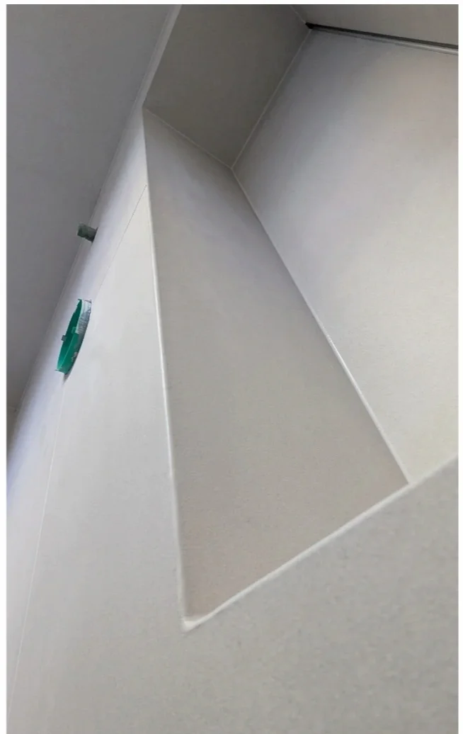 Close-up of a white wall with a small rectangular cutout or recessed area.