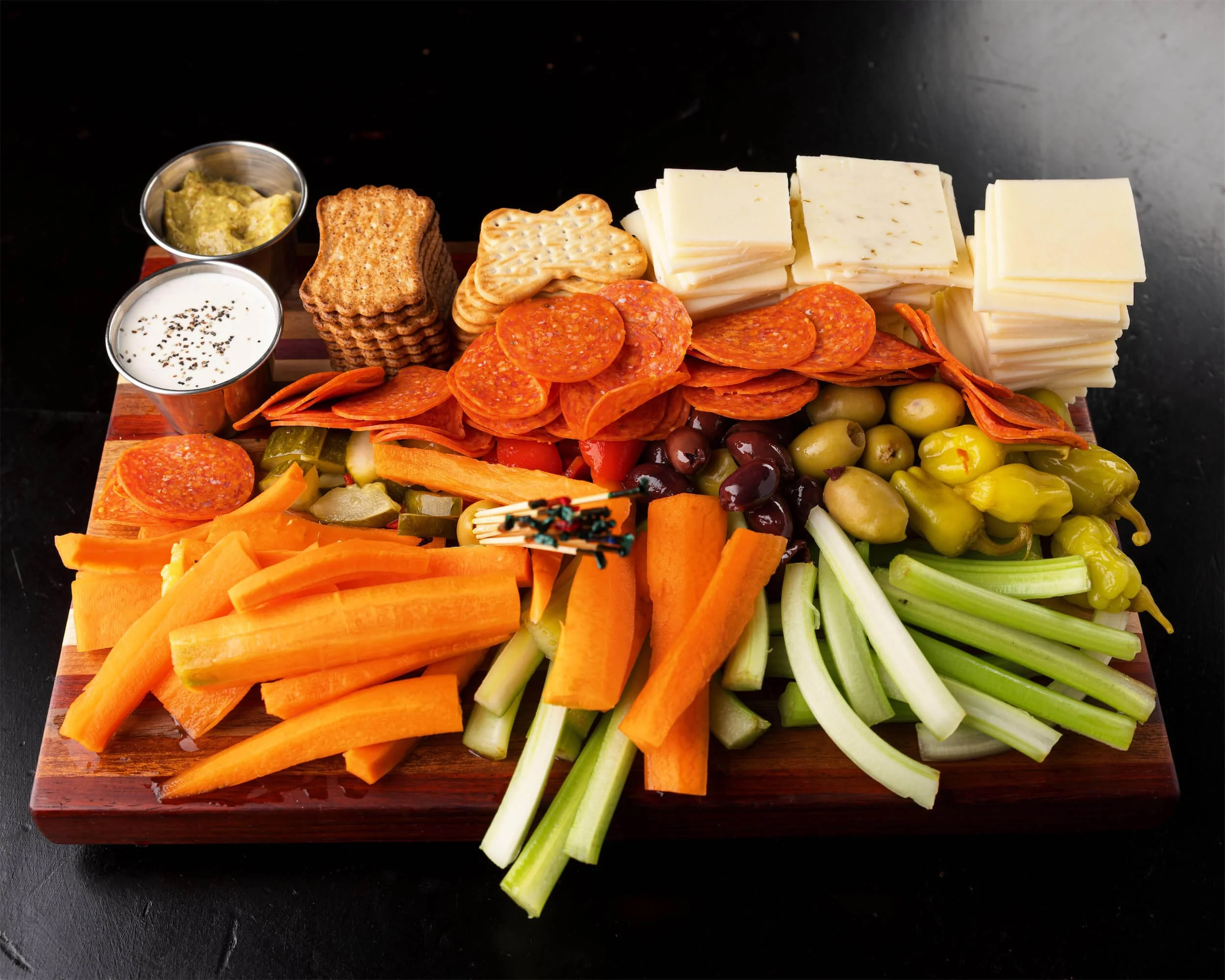 Charcuterie board with cheese, crackers, pepperoni, olives, carrots, celery, pickles, and dipping sauces at Ryan's Wake | An Irish Pub, Bar & Restaurant in Troy, NY with River Views, Outdoor Seating & Live Music