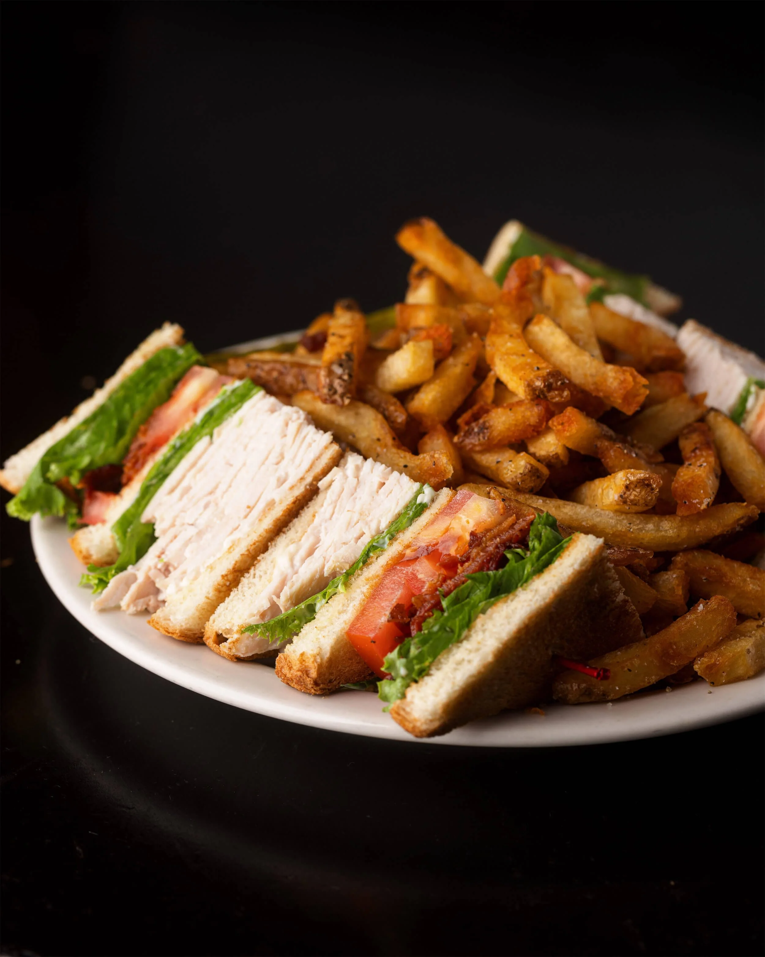 Club sandwich with lettuce, tomato, chicken, bacon, served with French fries  at Ryan's Wake | An Irish Pub, Bar & Restaurant in Troy, NY with River Views, Outdoor Seating & Live Music