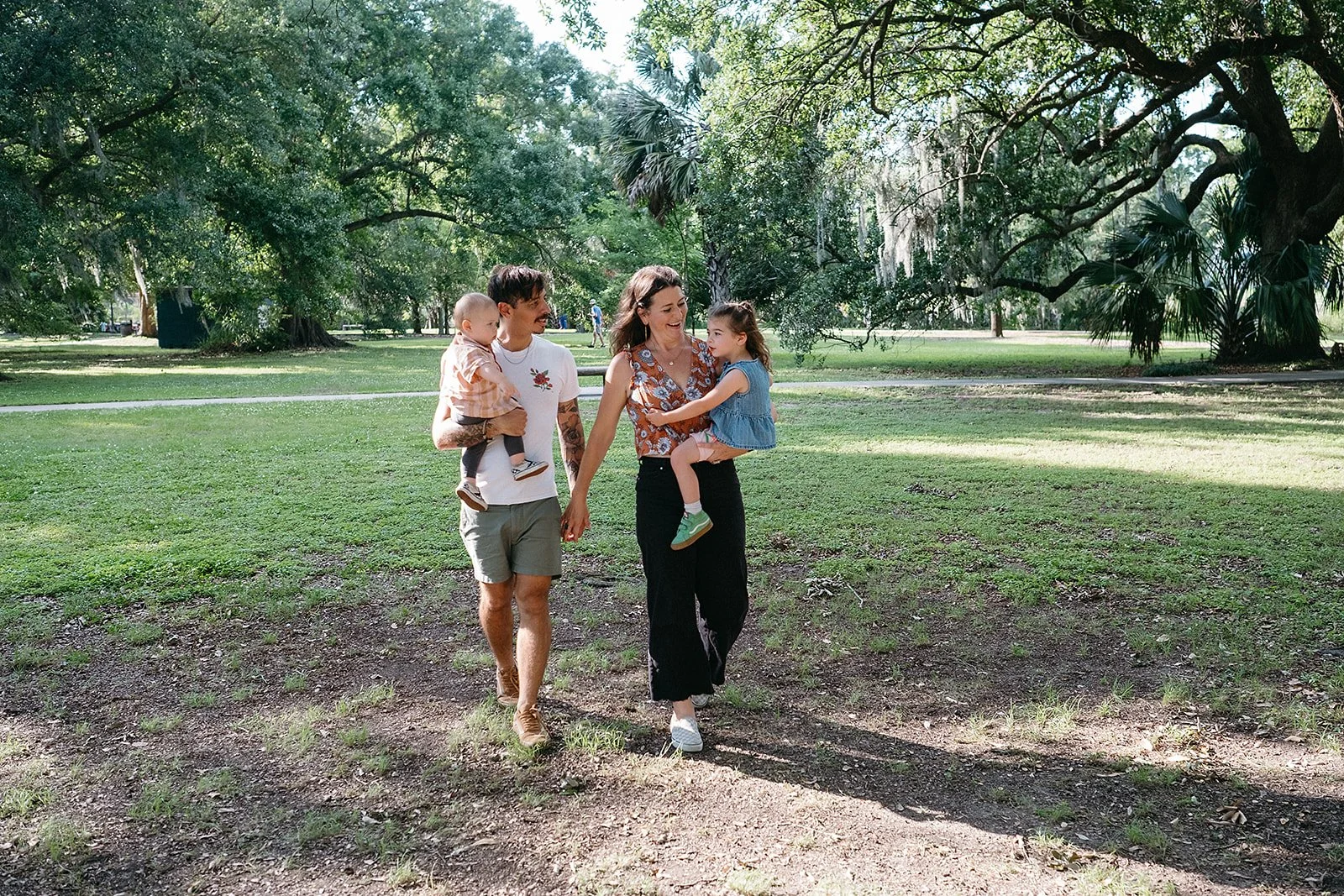 Family enjoying a walk in City park, New Orleans during their family photo session