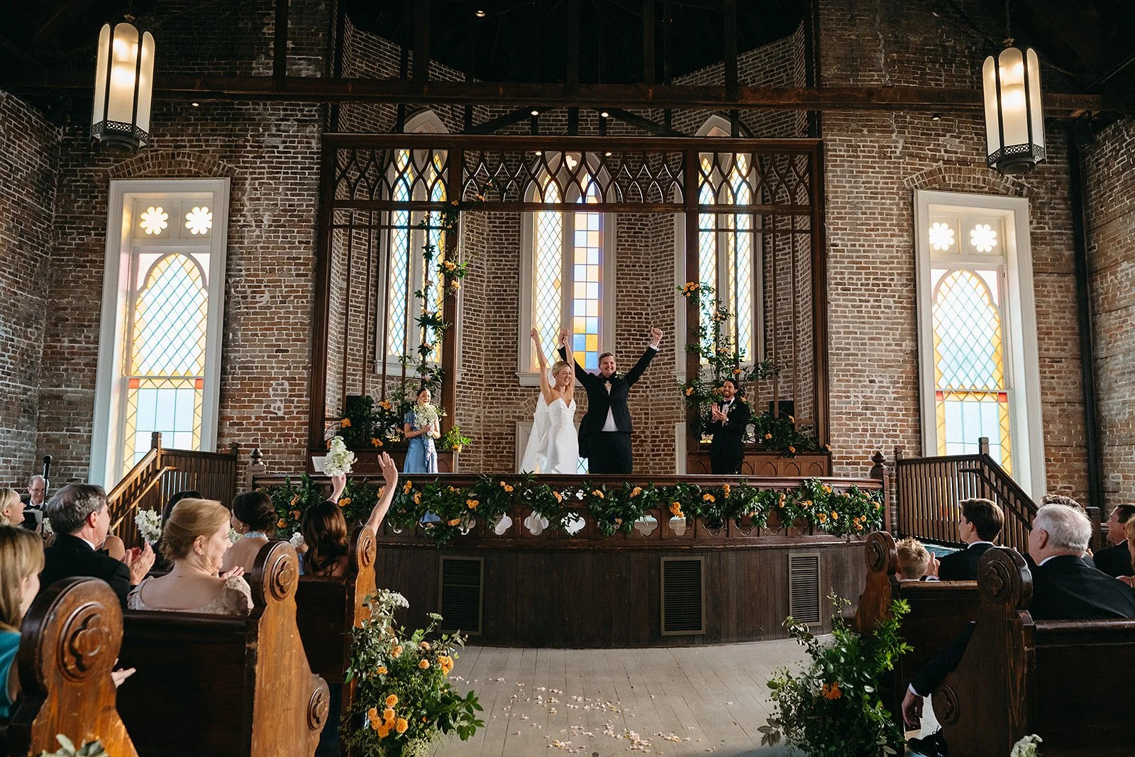 Wedding ceremony at The Felicity Church in the lower garden district in New Orleans.  Bride and groom and entire wedding party celelbrating!
