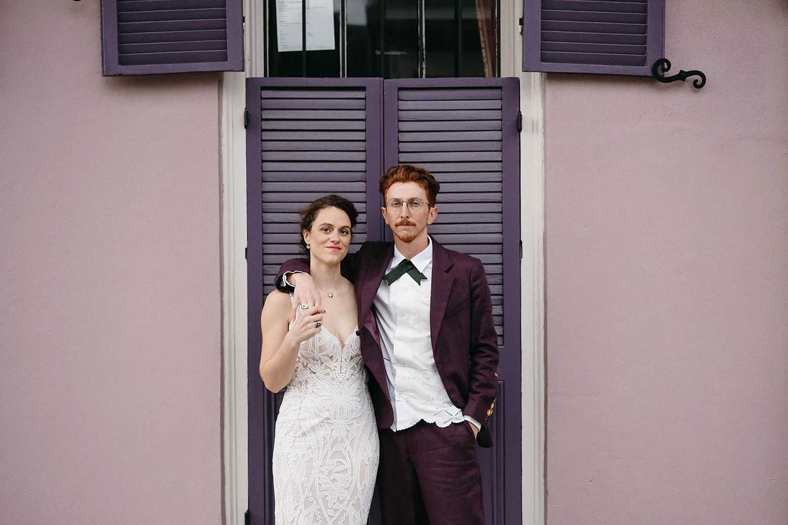 Bride & Groom standing in front of French Quarter shutters on their wedding day in New Orleans