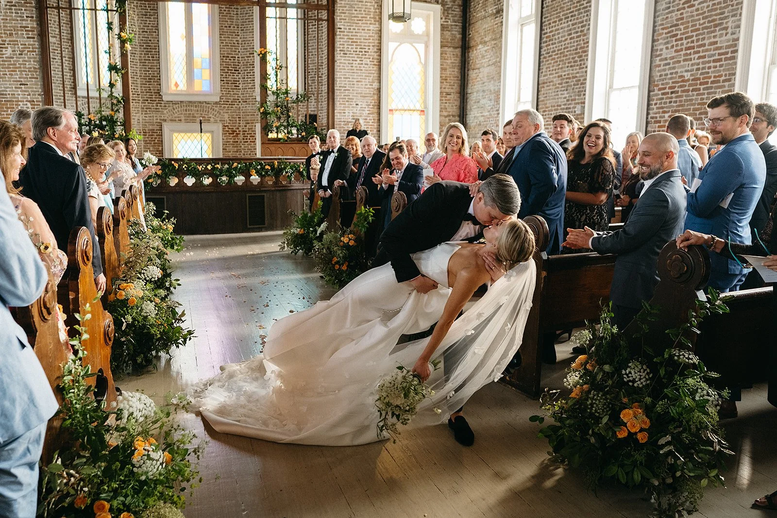 Couple kissing in the Aisle at The Felicity Church during their wedding in the Lower Garden District, New Orleans