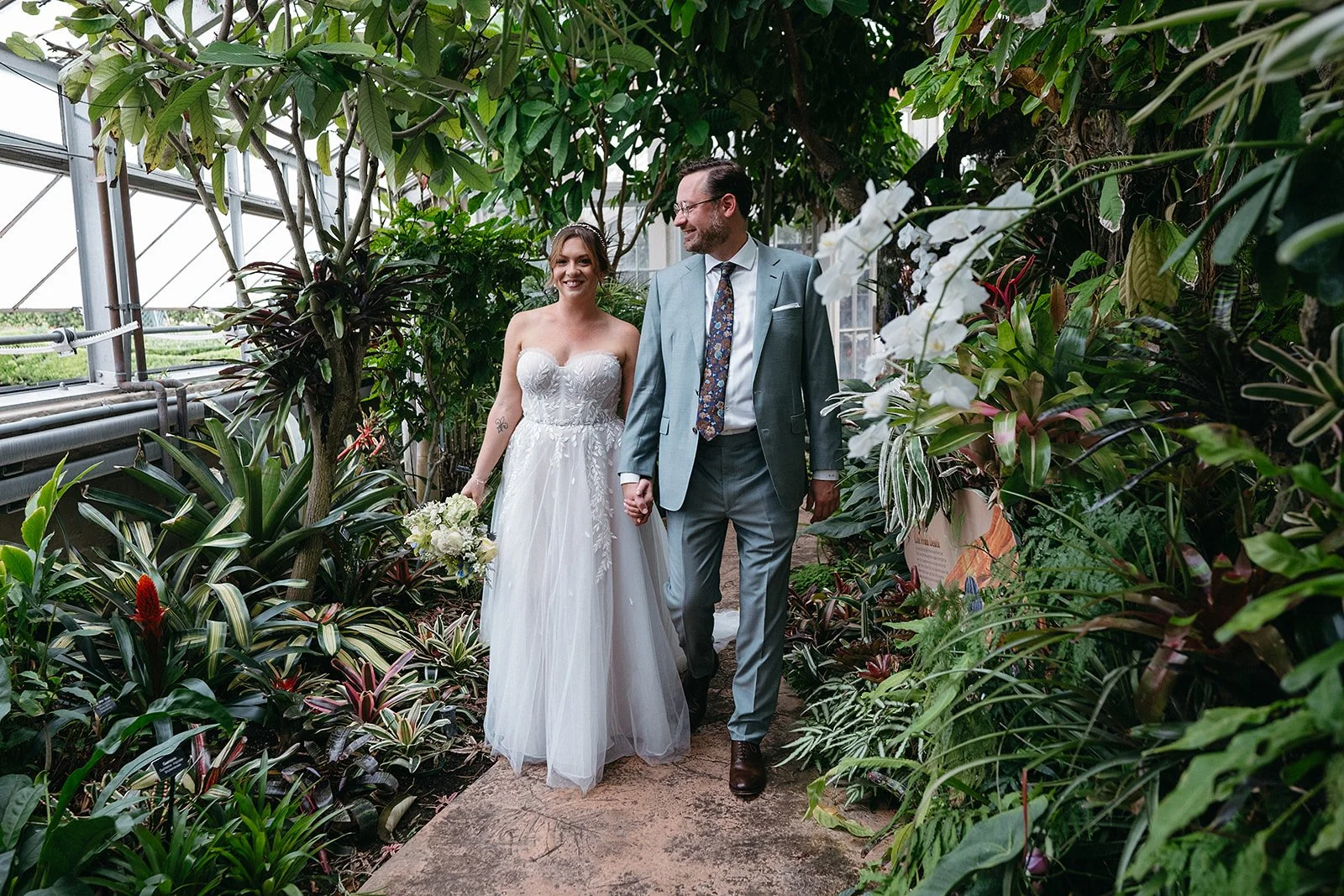 Bride and groom walking in the botanical gardens at City park in New Orleans on their wedding day.