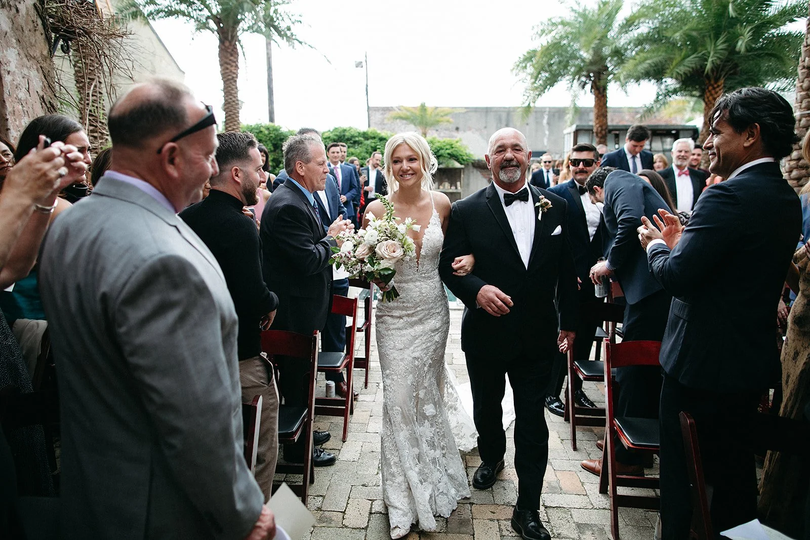 Bride walking down the aisle at her wedding at Race & Religious in New Orleans.  Holding her bridal bouquet, white wedding dress. 