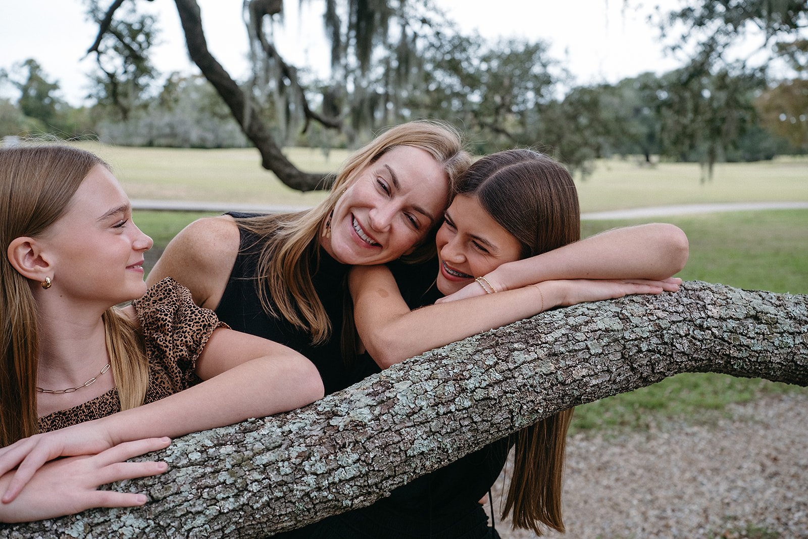 Mom and her daughters taking a moment together in Audubon Park, New Orleans during their family photo session