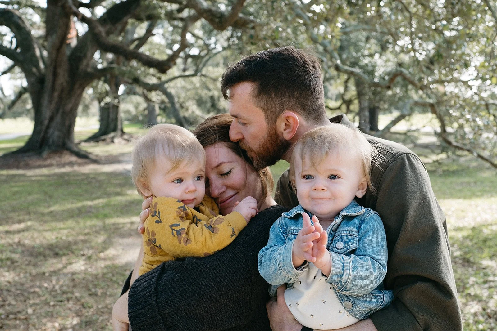 Dad holding twins and mom during family photo session at Audubon Park in New Orleans