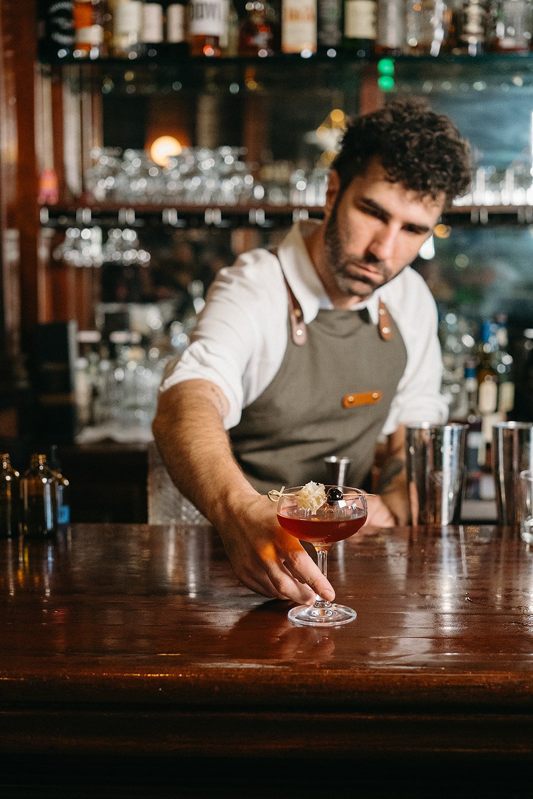 Bartender sliding signiature cocktail during a brand activation at Coquette during the Tales Of The Cocktail