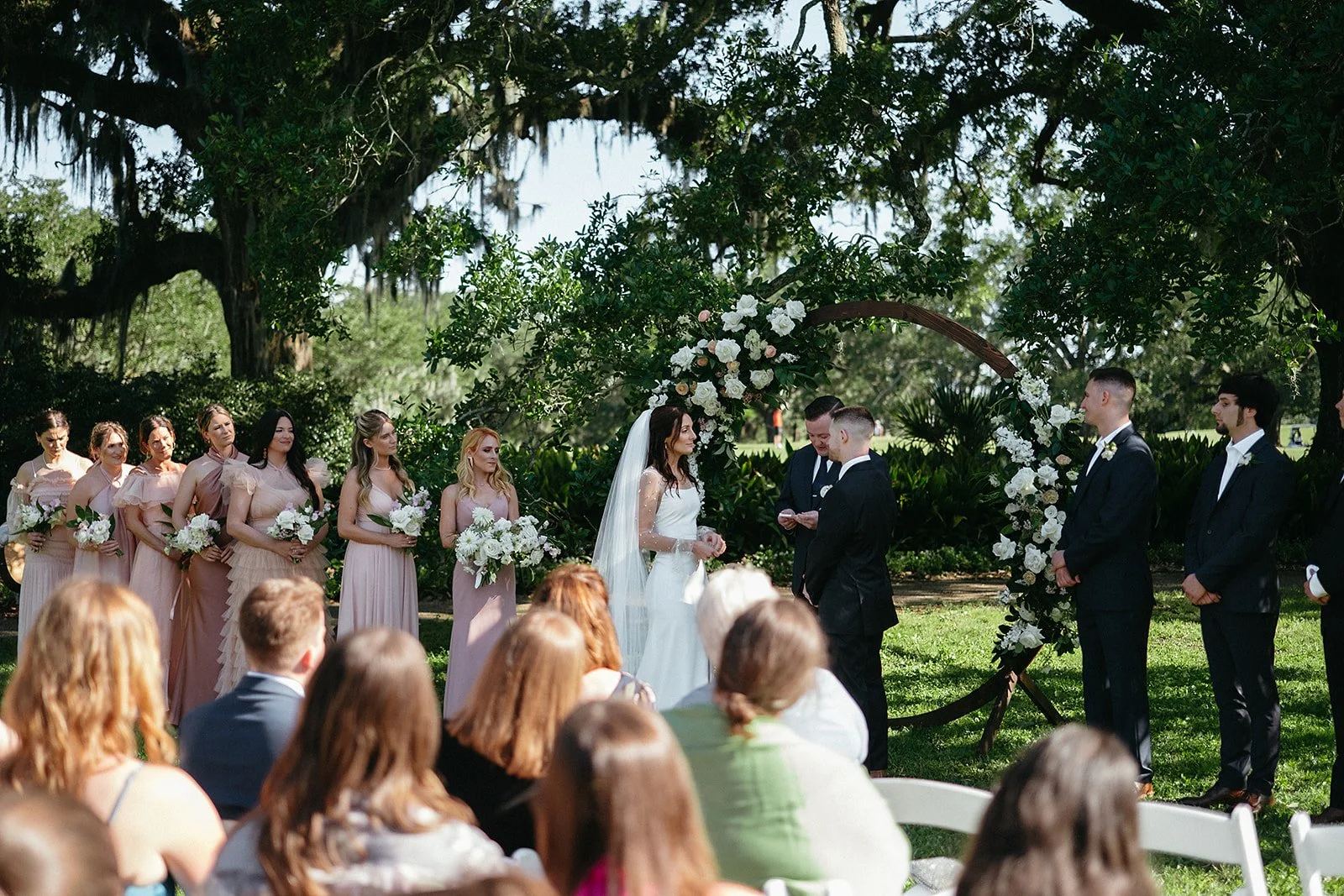 Bride, groom, bridal party during wedding ceremony under the Oak trees at Audubon Park, New Orleans