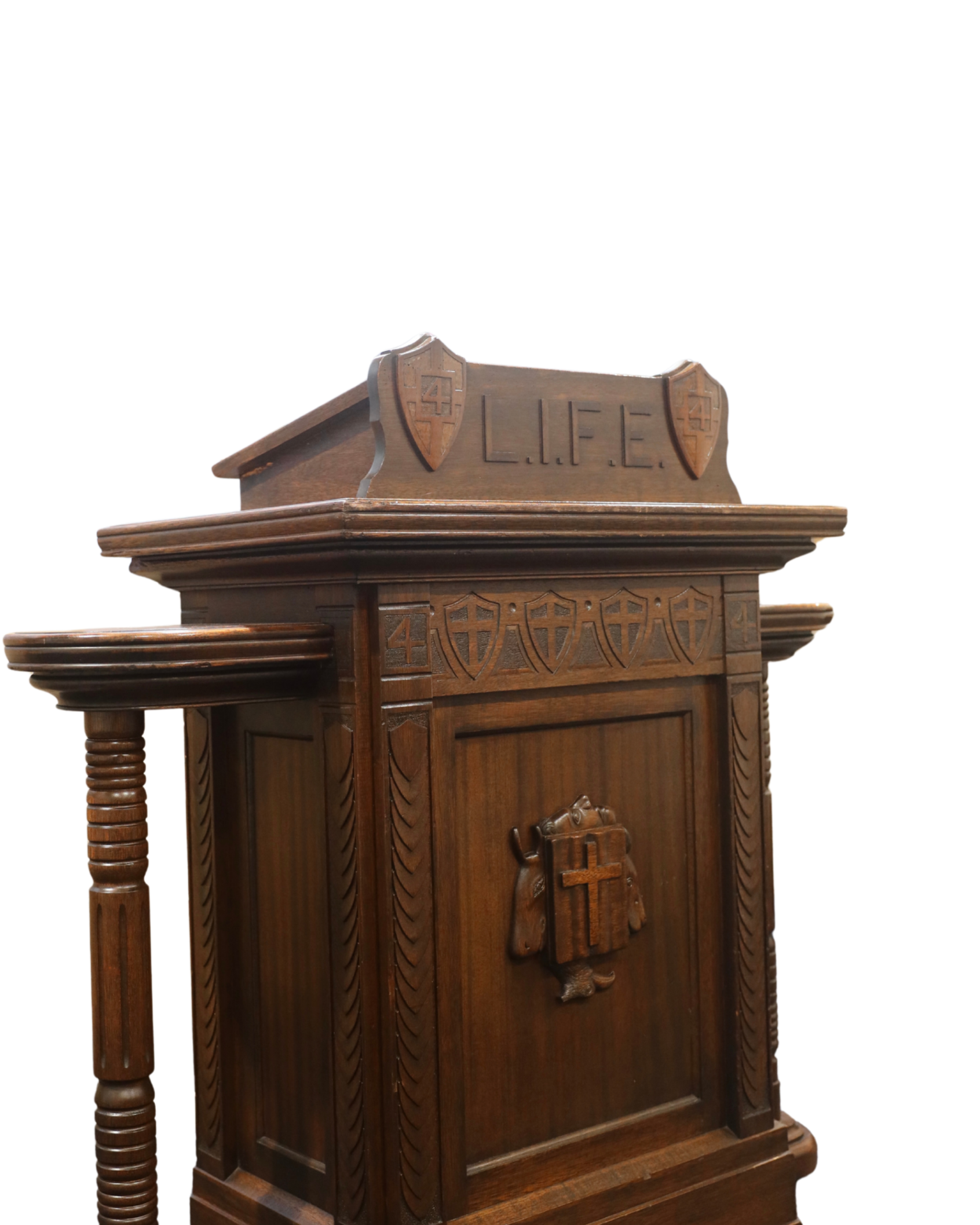 Wooden prayer or confessional box with carvings, shields, and the word 'LIFE' at the top, featuring a cross and other religious symbols.