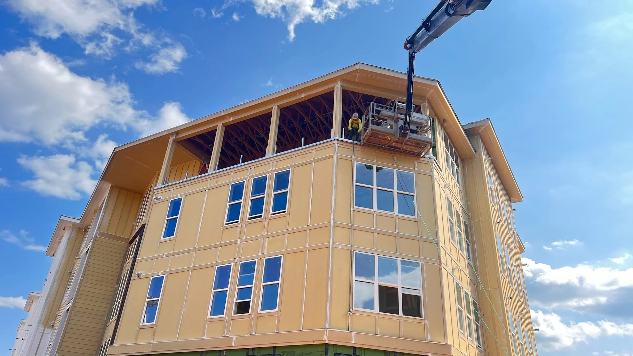 New yellow multi-story apartment complex under construction.