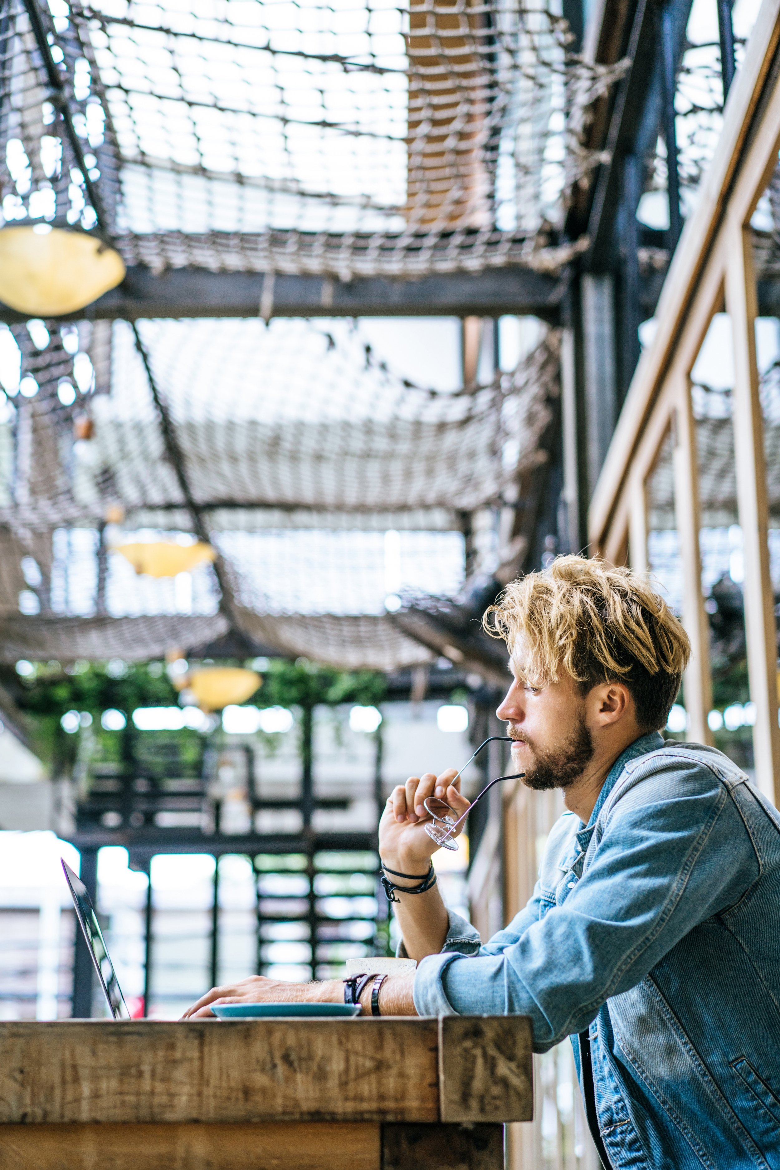 young-attractive-business-man-cafe-works-laptop-drinks-coffee.jpg