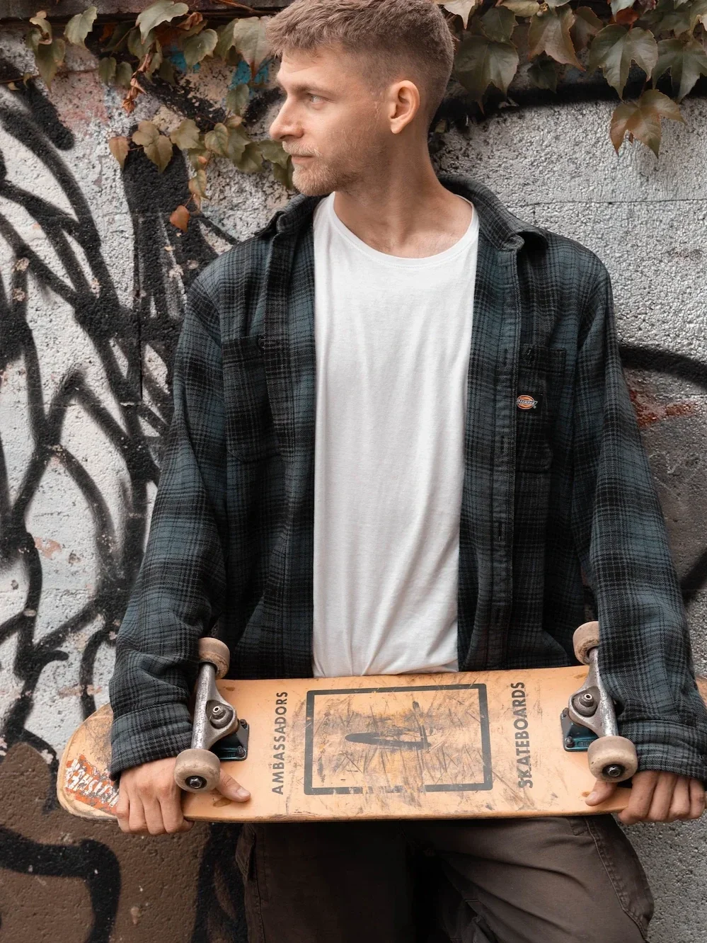 Portrétní fotka fotografa držící skateboard.