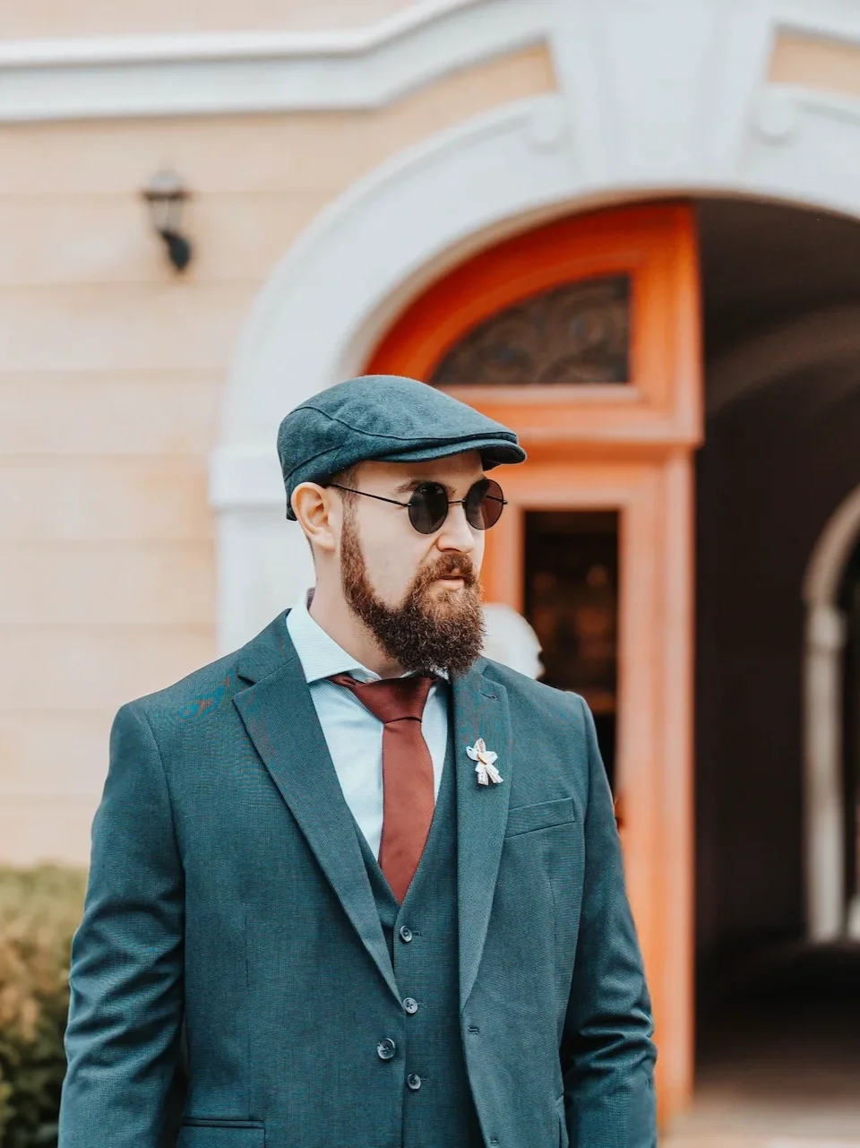 Muž ve společenském oblečení s plnovousem zachycen fotografem na portrétu.