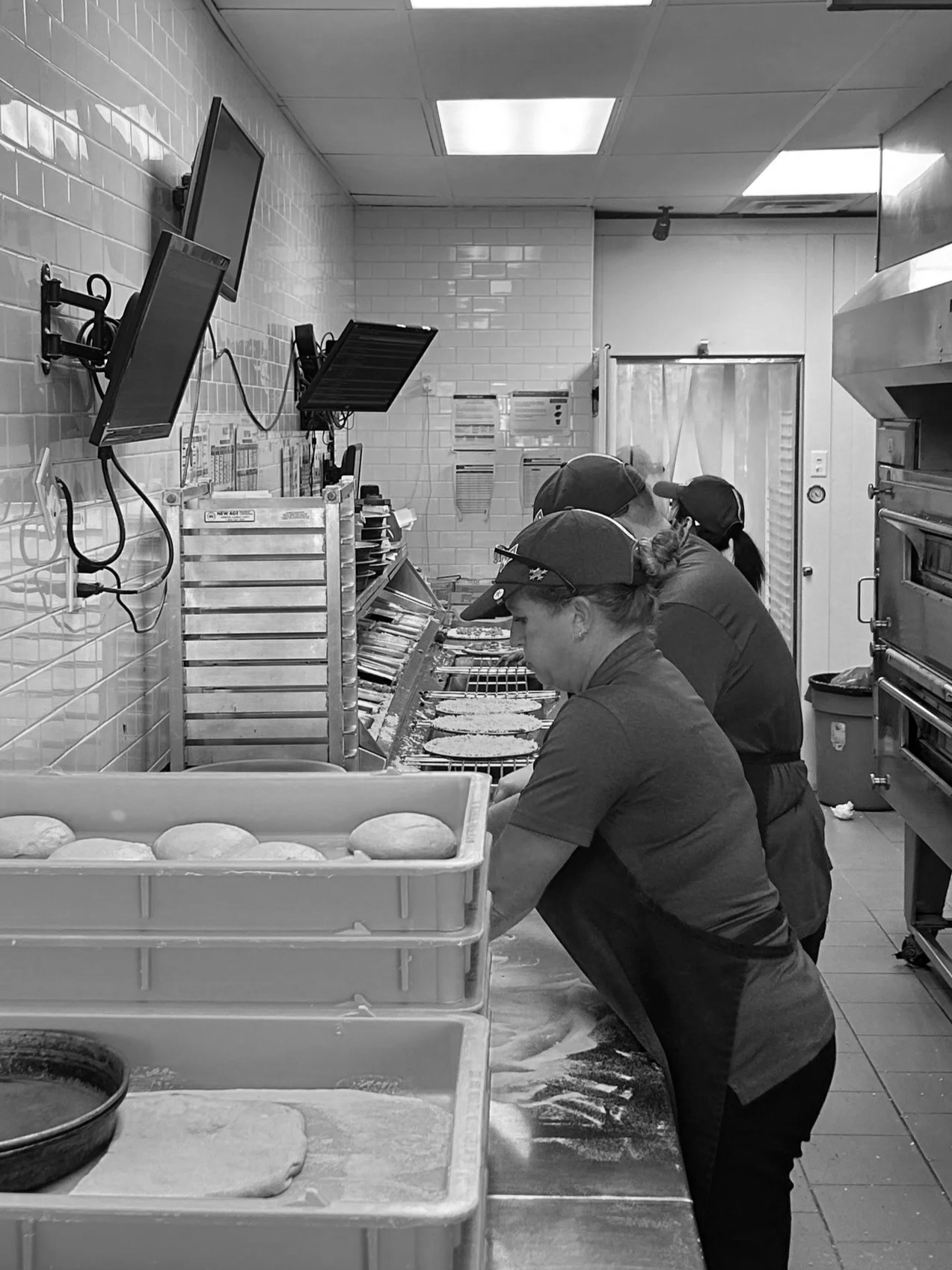 Live action of Pizza makers making product at a local Domino's Pizza.