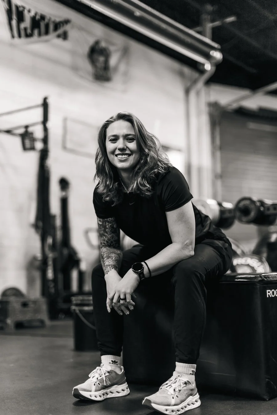 Kait Taylor, founder of Origin Wellness, seated in a gym in Washington, DC, Navy Yard location - specializing in personalized fitness coaching and strength training.