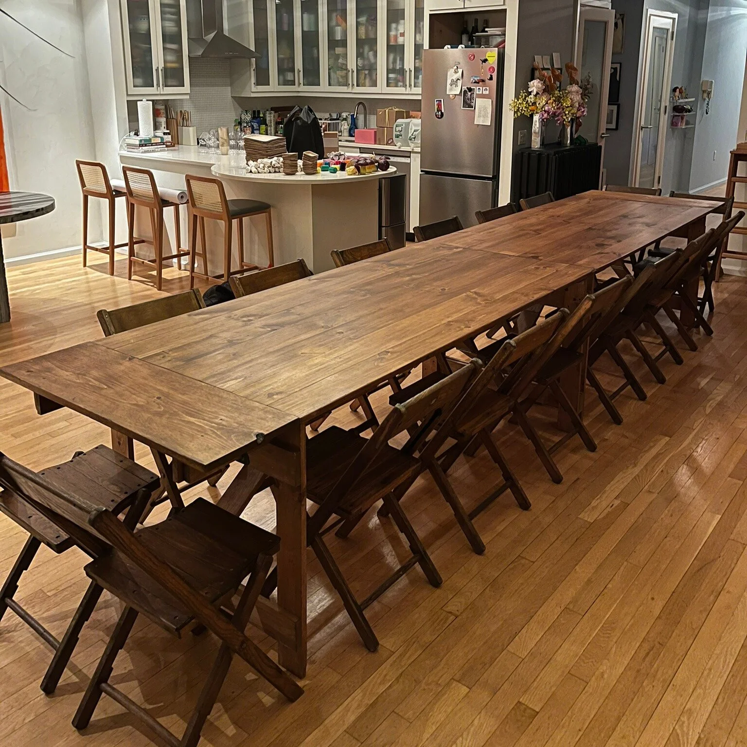 KRAUS folding farm table with end extension leaves and vintage wooden chairs, indoor banquet setup