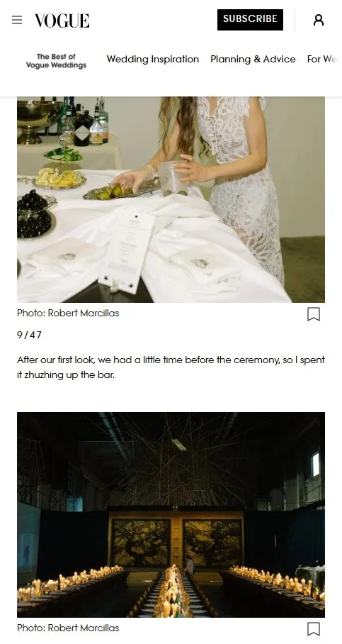 A woman in a lace wedding dress standing at a bar with bottles and fruit on the counter, holding a glass. The setting appears to be before a wedding ceremony.