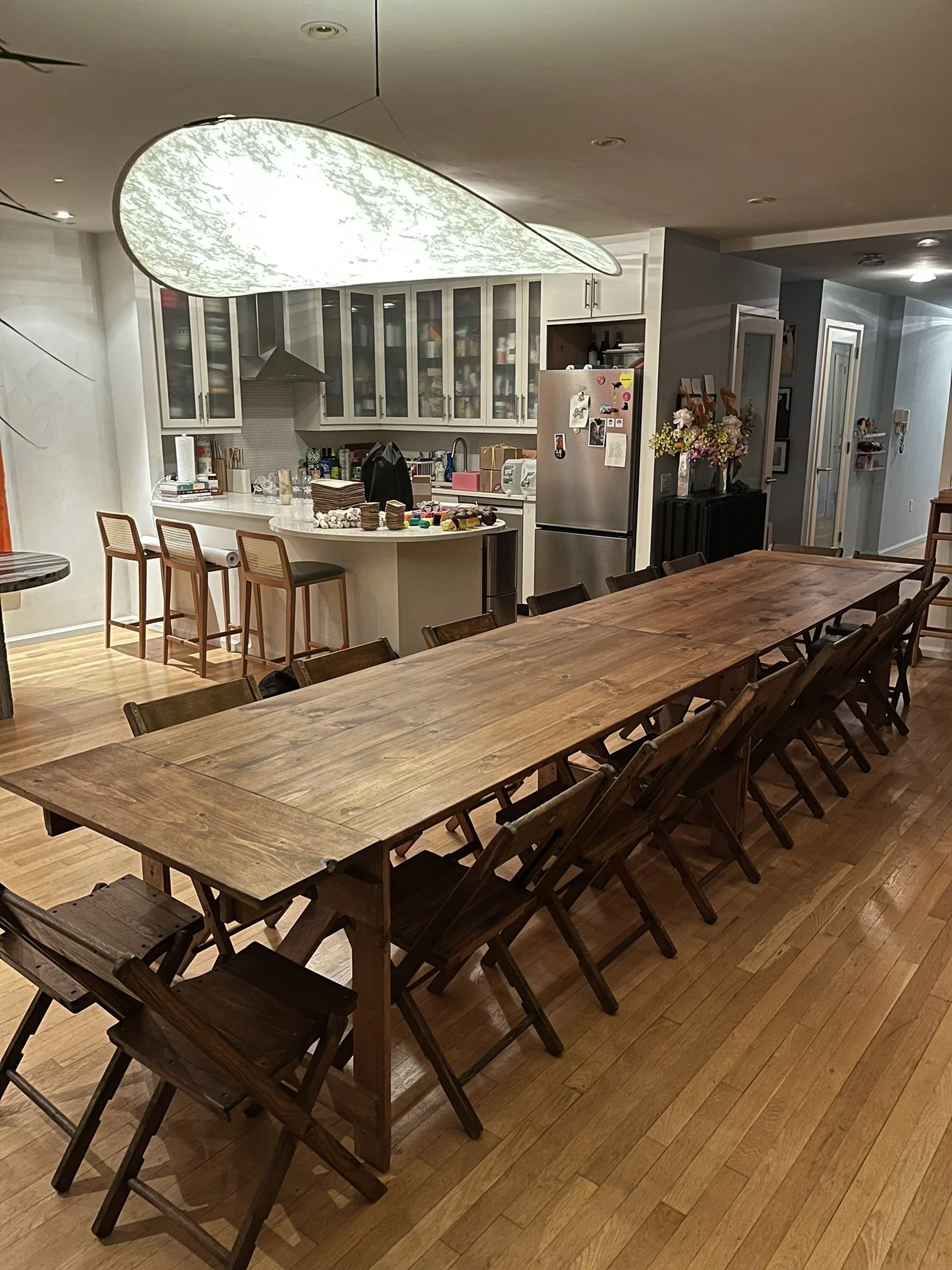 Handmade folding farm table with vintage wooden folding chairs set for a birthday dinner in a West Village NYC apartment.