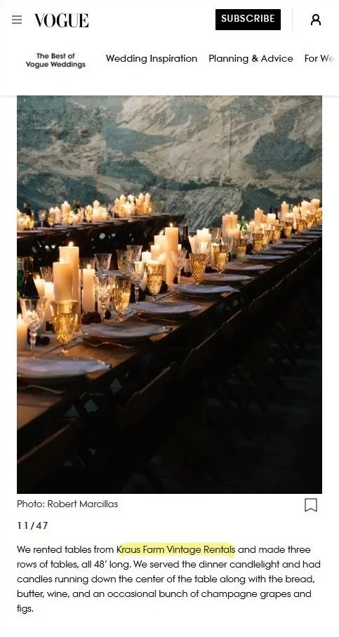 A long dining table decorated with candles and glassware, set for a formal meal. A mountain portrait is visible in the background.