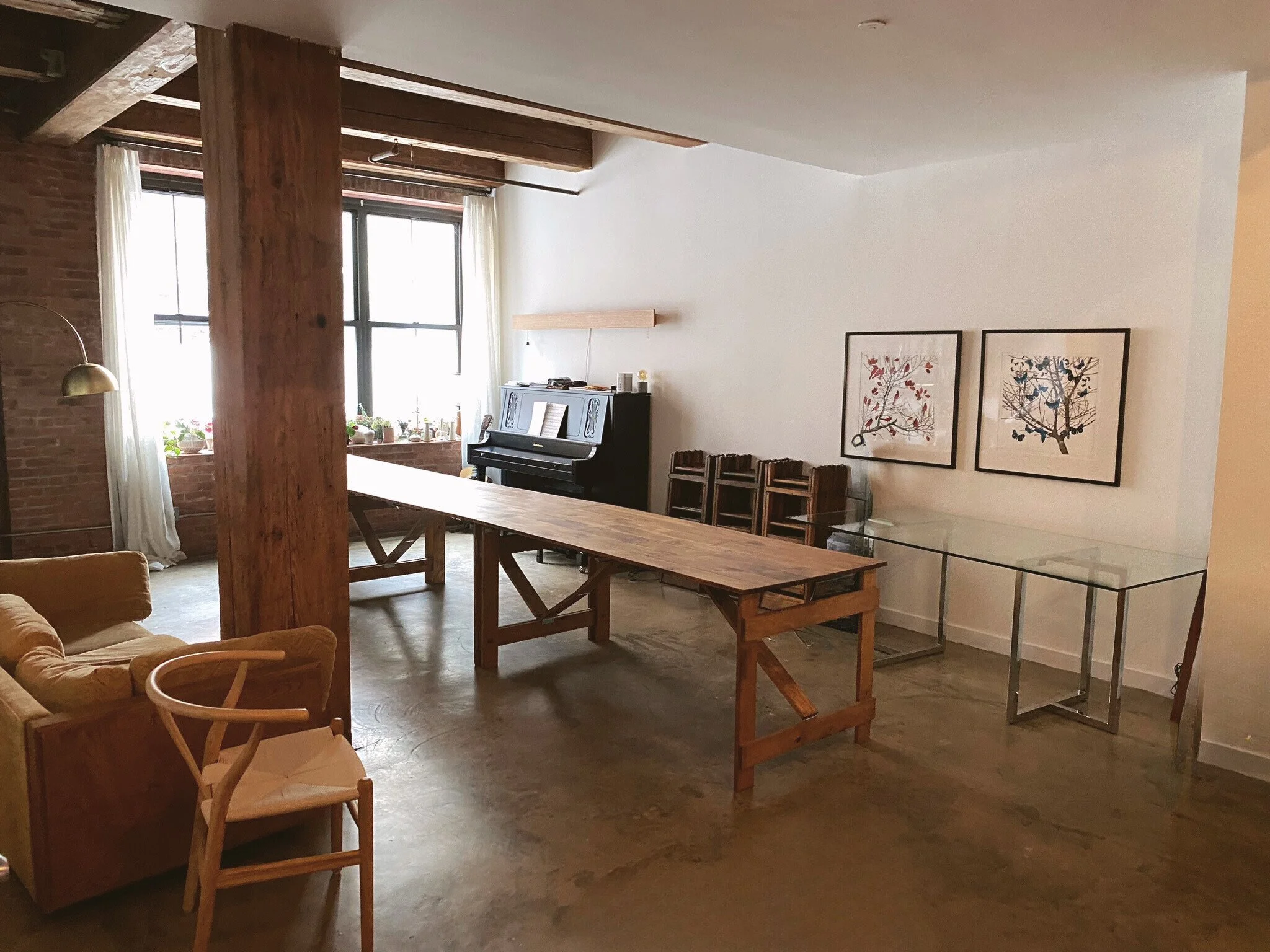 Handmade folding farm table paired with vintage wooden folding chairs set inside a Greenpoint Brooklyn loft dining space.