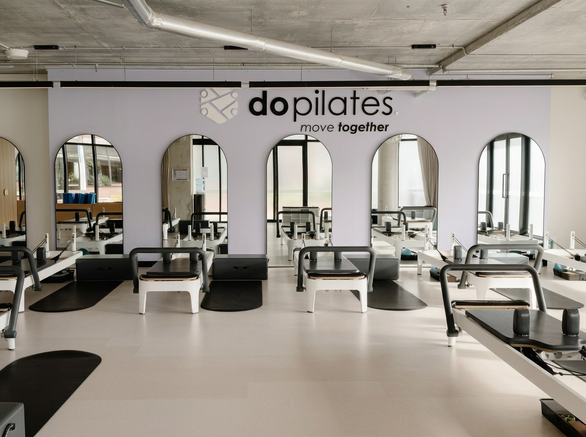 Light-filled do pilates studio in Kensington with Reformer Pilates machines, wall mirrors and the words “move together”.