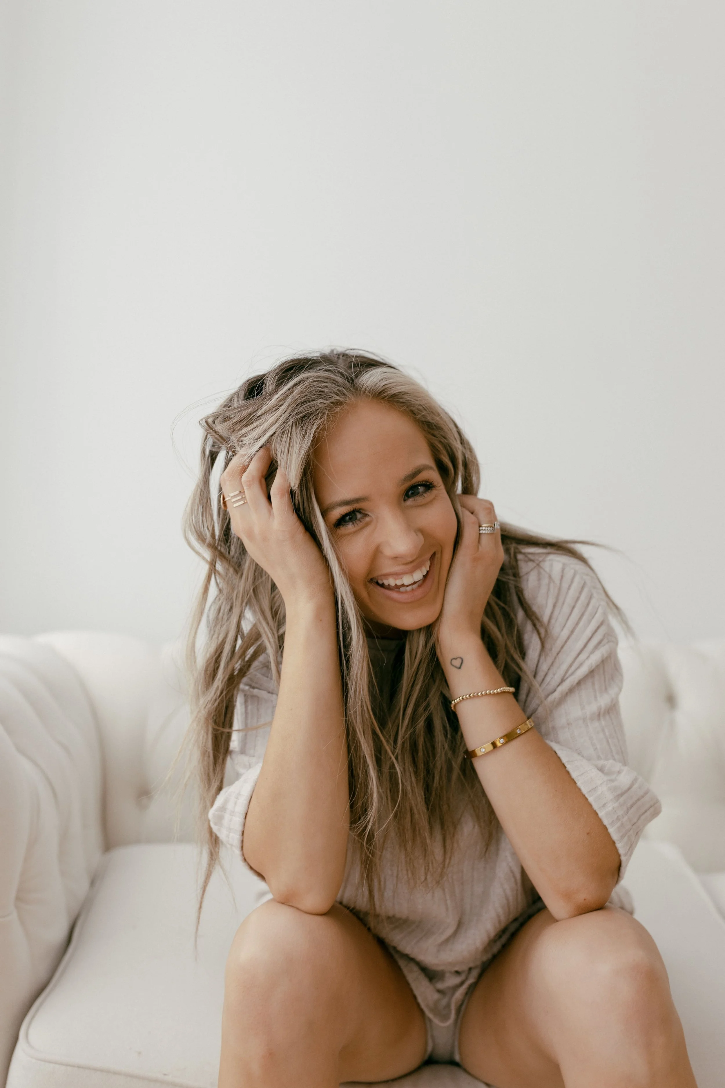Next Chapter Studio founder Tyler, a Glens Falls motherhood and family photographer, laughing in her studio.