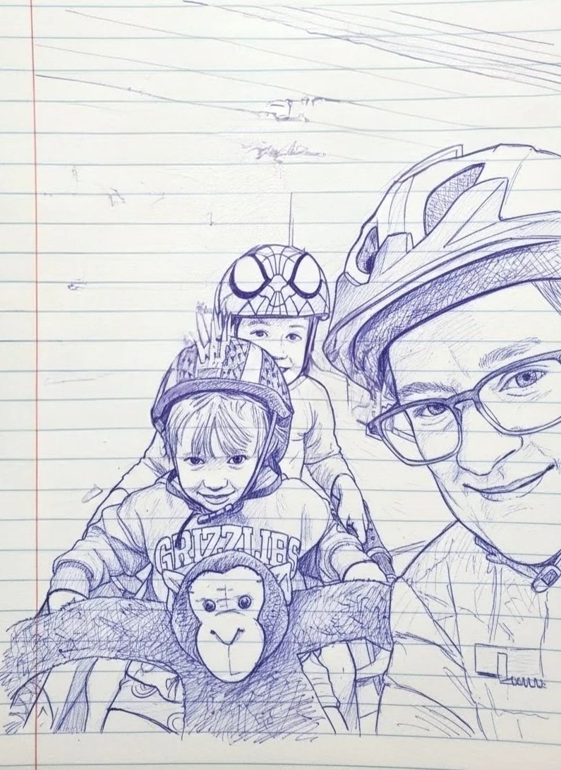 Family including mother, two smiling children and a monkey stuffie wearing helmets for a bike ride.
